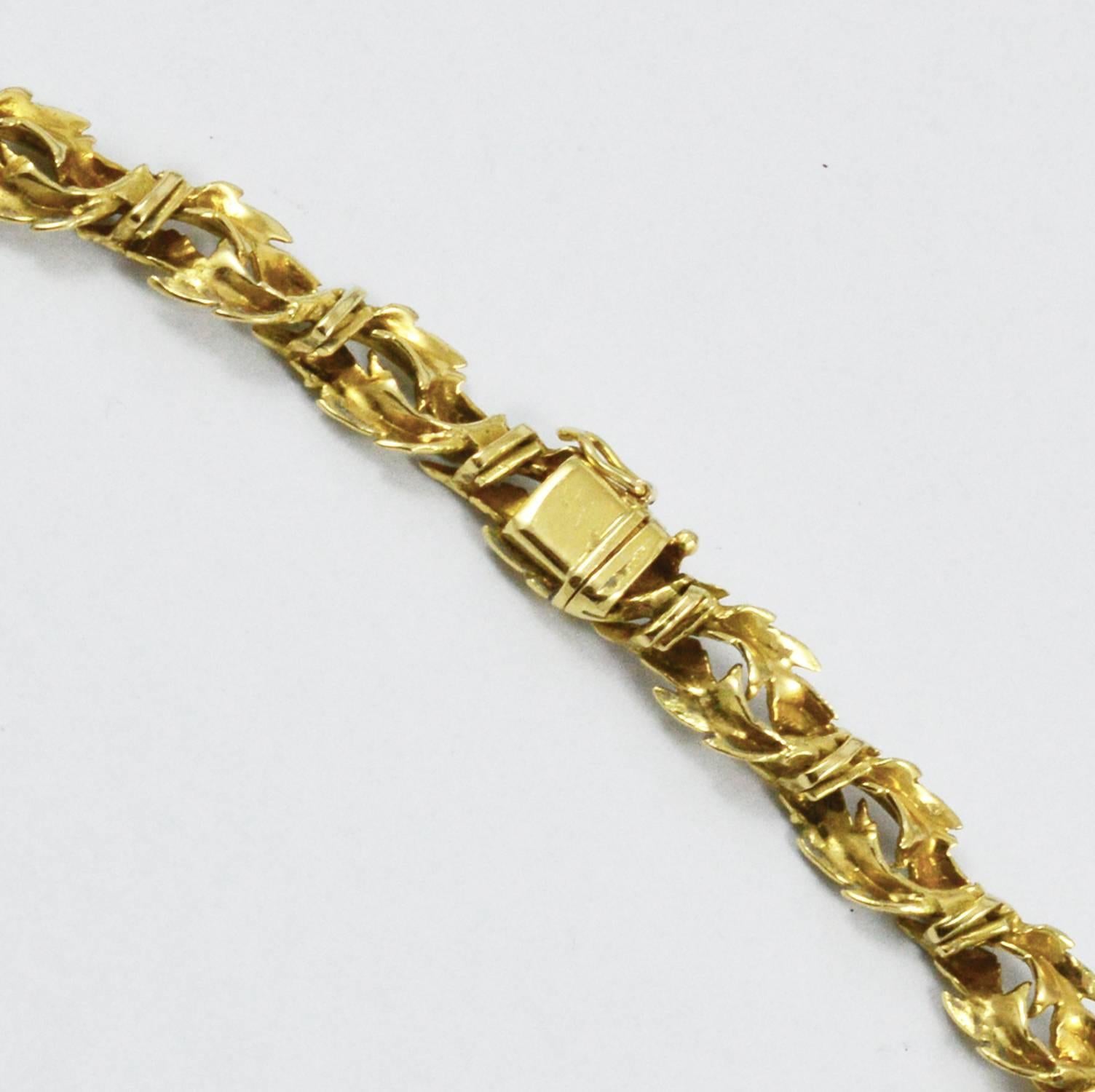 A beautiful French necklace designed as a garland of diamond encrusted 18K yellow gold leaves. This necklace is clearly stamped with French touch marks and was made circa 1960. This piece is hand made and holds 13 high quality diamonds (.72 ct. F-G,