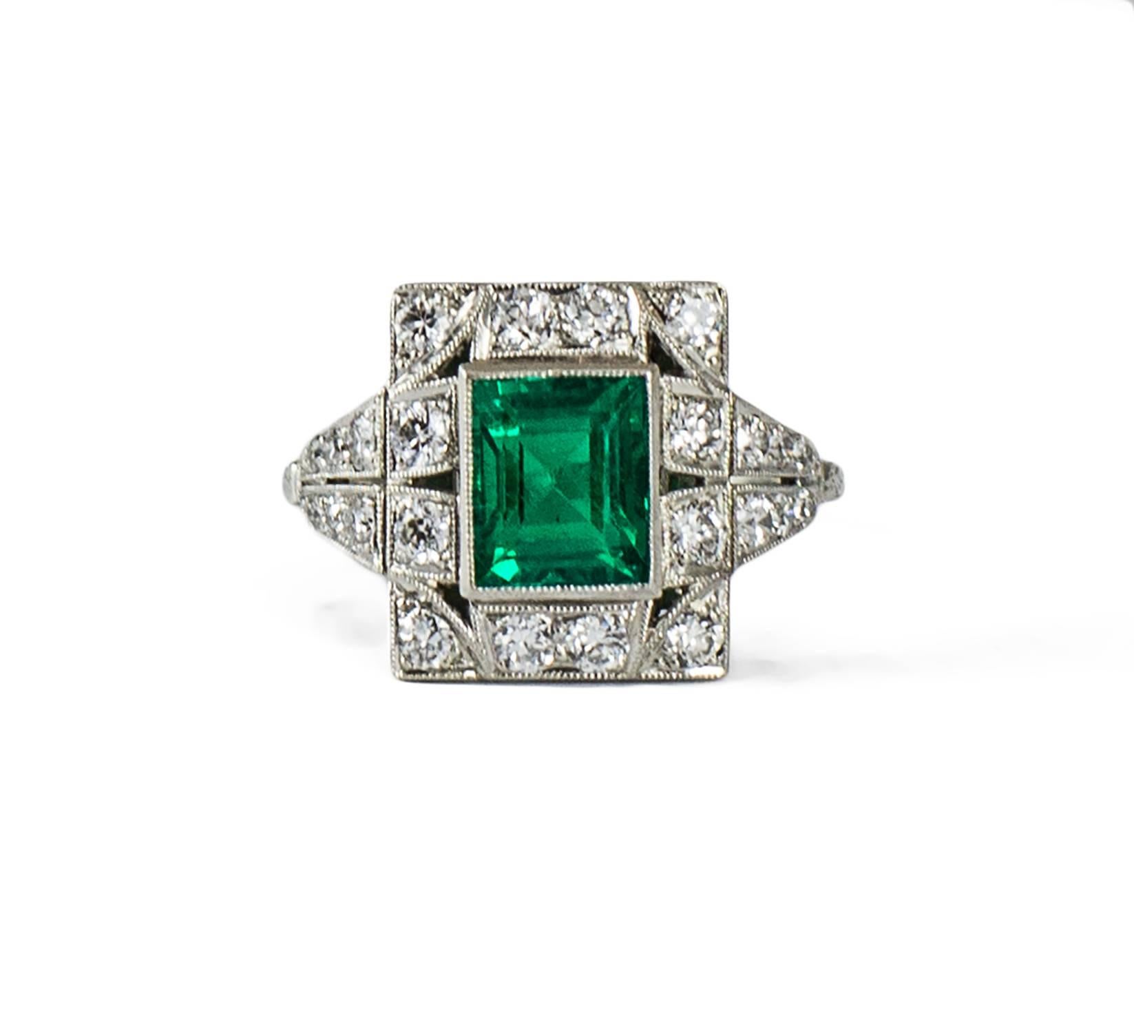 A simply lovely custom made Art Deco ring set in platinum and made circa 1930. The ring holds a vibrant deep transparent green emerald weighing 1.28 ct. tw. Additionally, there are 24 high quality bead set old European cut diamonds (G-H, VS-SI)