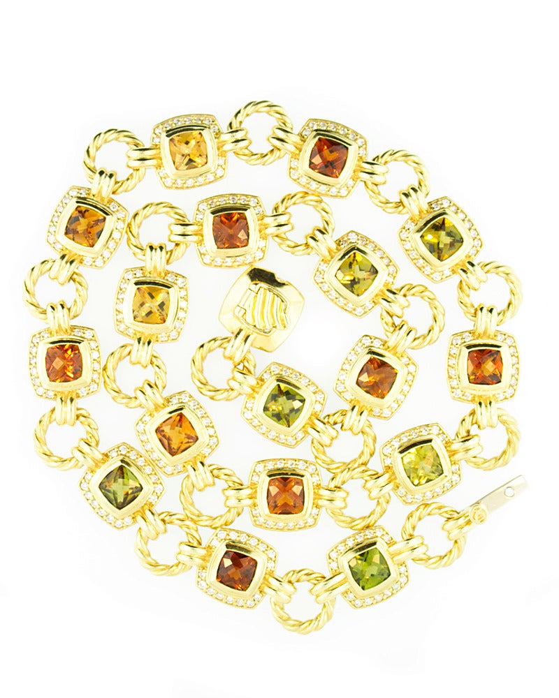 This David Yurman necklace is set in 18kt yellow gold. The classic Yurman cable link connects square set citrine and peridot gemstones surrounded by 2.40ct brilliant cut high quality diamonds. This piece measures 16 inches. This necklace is in