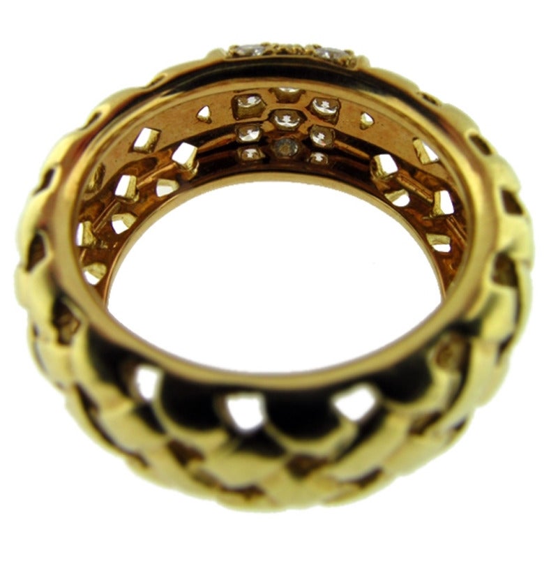 This TIFFANY & CO. 18k yellow gold ring is from the Vannerie Collection. The 14 high quality round brilliant cut diamonds total .58cts. The ring measures size 5 3/4 and is in excellent condition.