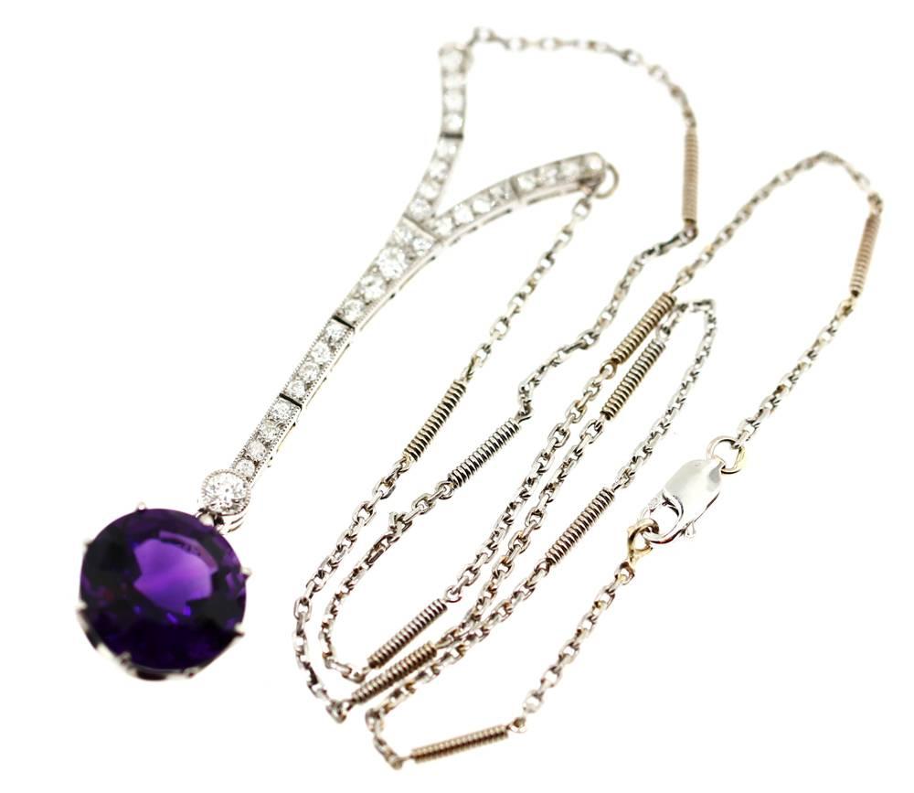 This exceptional necklace is set in platinum. It contains .90cts old European cut diamonds which are white and bright. The central drop holds a stunning round step cut amethyst weighing 10cts.The amethyst is a deep intense purple. The chain