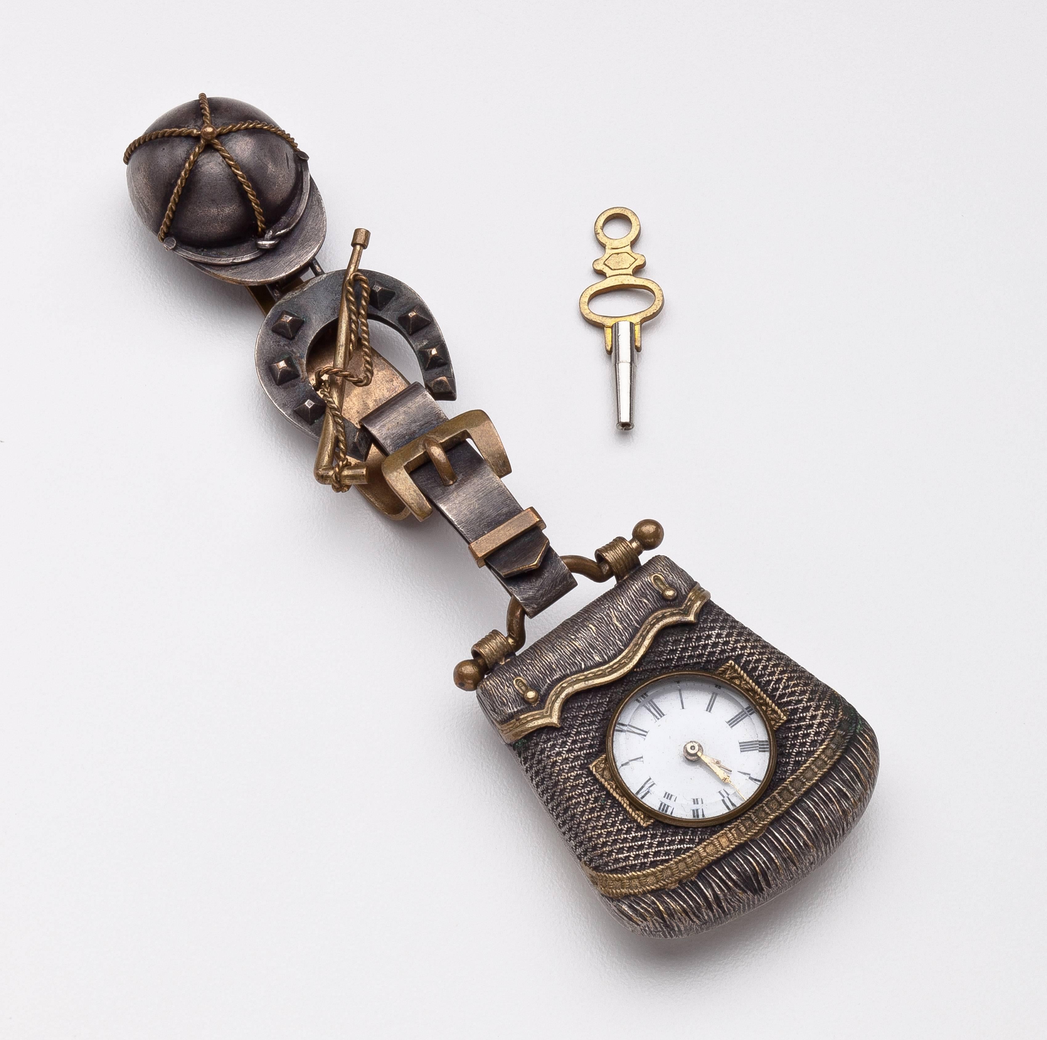 Victorian Key-wound watch with equestrian-style case and chatelaine. Mid-19th century watch with cylinder movement has porcelain dial with Roman numerals. The gun-metal and brass chatelaine case composed of several elements: saddle bag with watch,