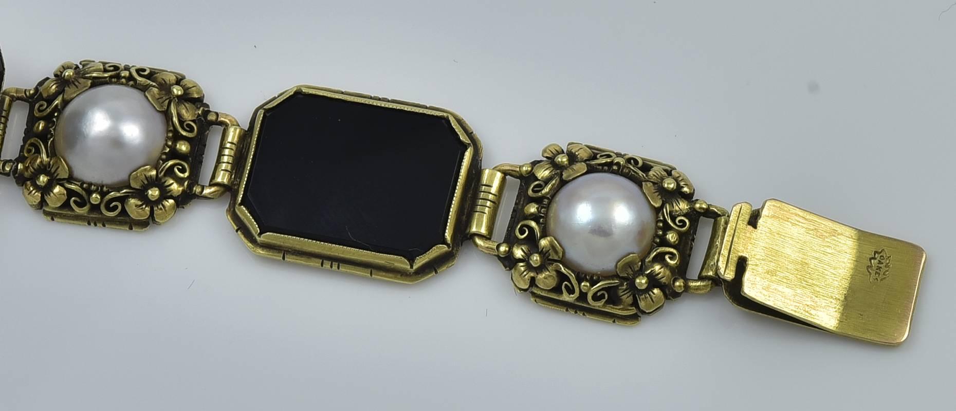 Oakes Studios Gold, Onyx and Pearl Bracelet. This American Arts and Crafts bracelet was made by the Oakes studio and attributed to Edward Oakes. The bracelet measures 7.25 inches long and .5 inches wide. The bracelet is composed of ten links each in