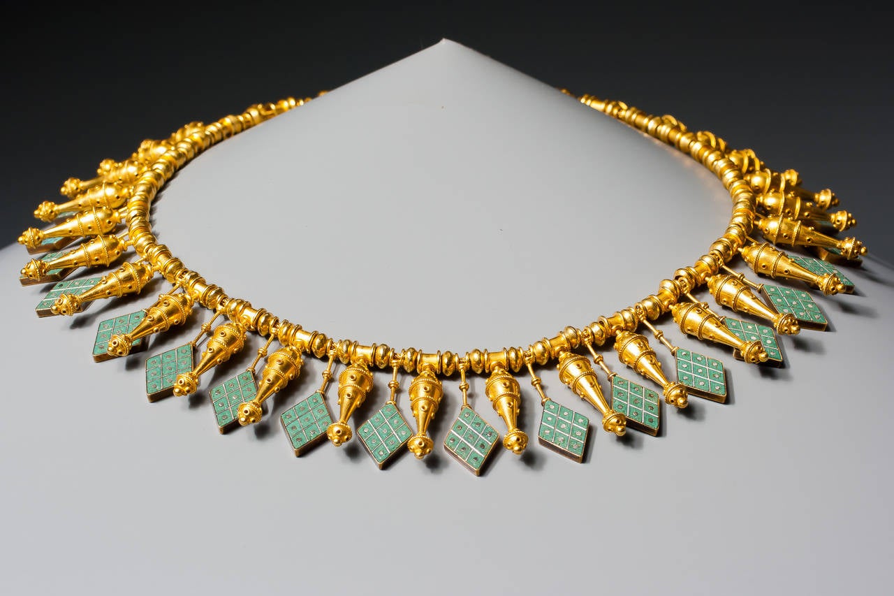 A rare archeological revival gold and micromosaic necklace by Castellani, 
the woven gold chain threaded with spherical and spool shaped gold beads, suspending a fringe of lozenge shaped turquoise coloured micromosaic drops, alternating with