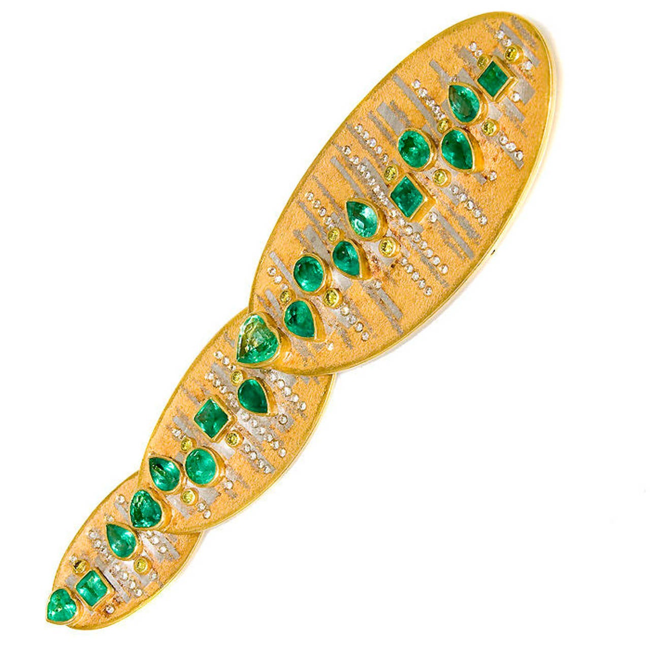 A one of a kind emerald and diamond pendant/brooch by Michael Zobel, mounted in 18 karat white and yellow gold, set with white and fancy greenish yellow diamonds and emeralds in various shapes.  
This piece is articulated and can be worn as a