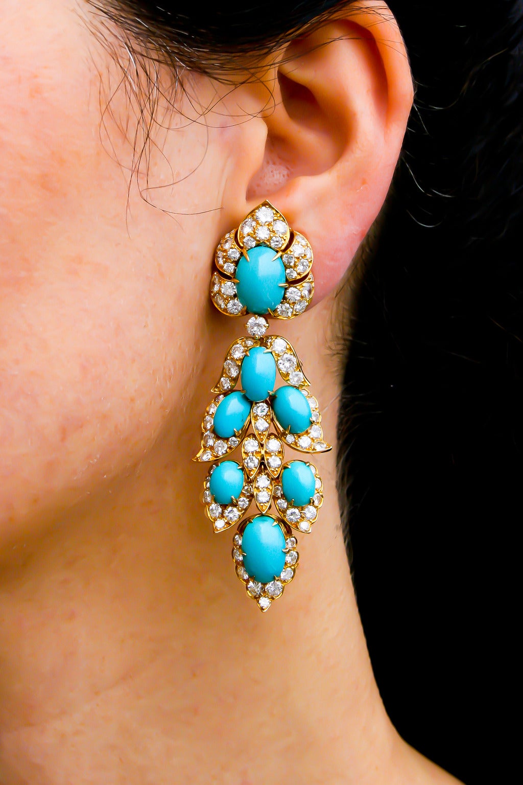 A magnificent pair of turquoise and diamond pendant earrings of oriental inspiration by Van Cleef and Arpels, each of stylised foliate design, set with cabochon turquoises and brilliant cut diamonds, mounted in 18 karat yellow gold.
Signed VAN