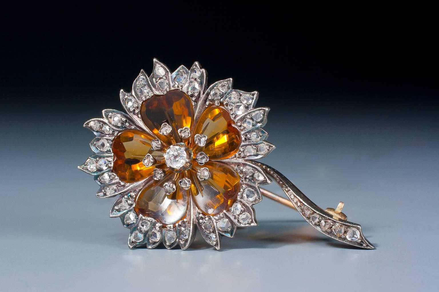 A charming Victorian citrine and diamond flower head brooch, each petal formed with a cabochon heart shaped citrine with rose cut diamond set tips, centered with a cluster of circular cut and rose cut diamonds, mounted in silver on gold.
French