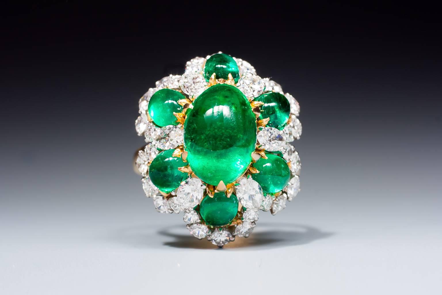 A very fine Colombian emerald and diamond ring, set with a magnificent large emerald cabochon, surrounded by smaller emerald cabochons and marquise shaped diamonds, in a brilliant cut diamond surround, mounted in 18 karat yellow gold. The emeralds