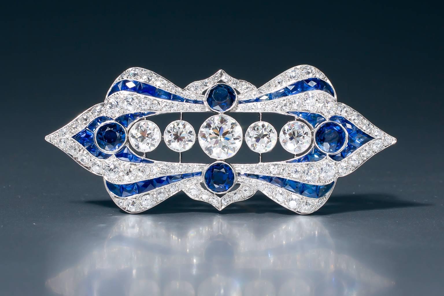 A spectacular Art Deco sapphire and diamond plaque brooch, set throughout with old European cut diamonds and calibré-cut sapphires. Five large old European cut diamonds and 4 large circular cut sapphires are collet set. 
The platinum mount shows