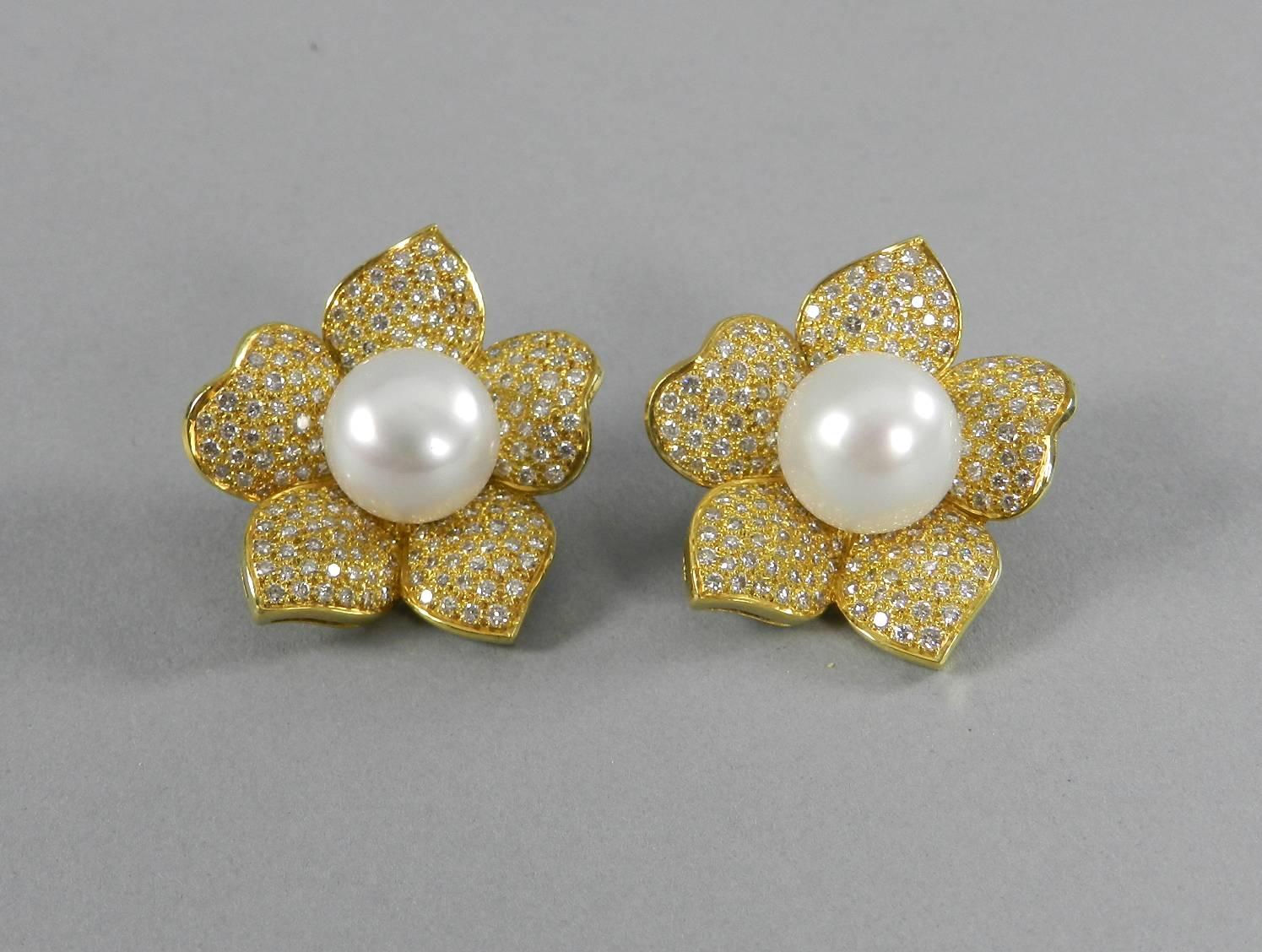 18k yellow gold, diamond, pearl, large flower clip earrings. 14mm pearl, approx. 3 carat total weight diamonds, 39.2 grams total weight. Measures 37 x 32mm. Back of earrings hallmarked 18k and clip back is hallmarked 14k. Excellent condition. 

We