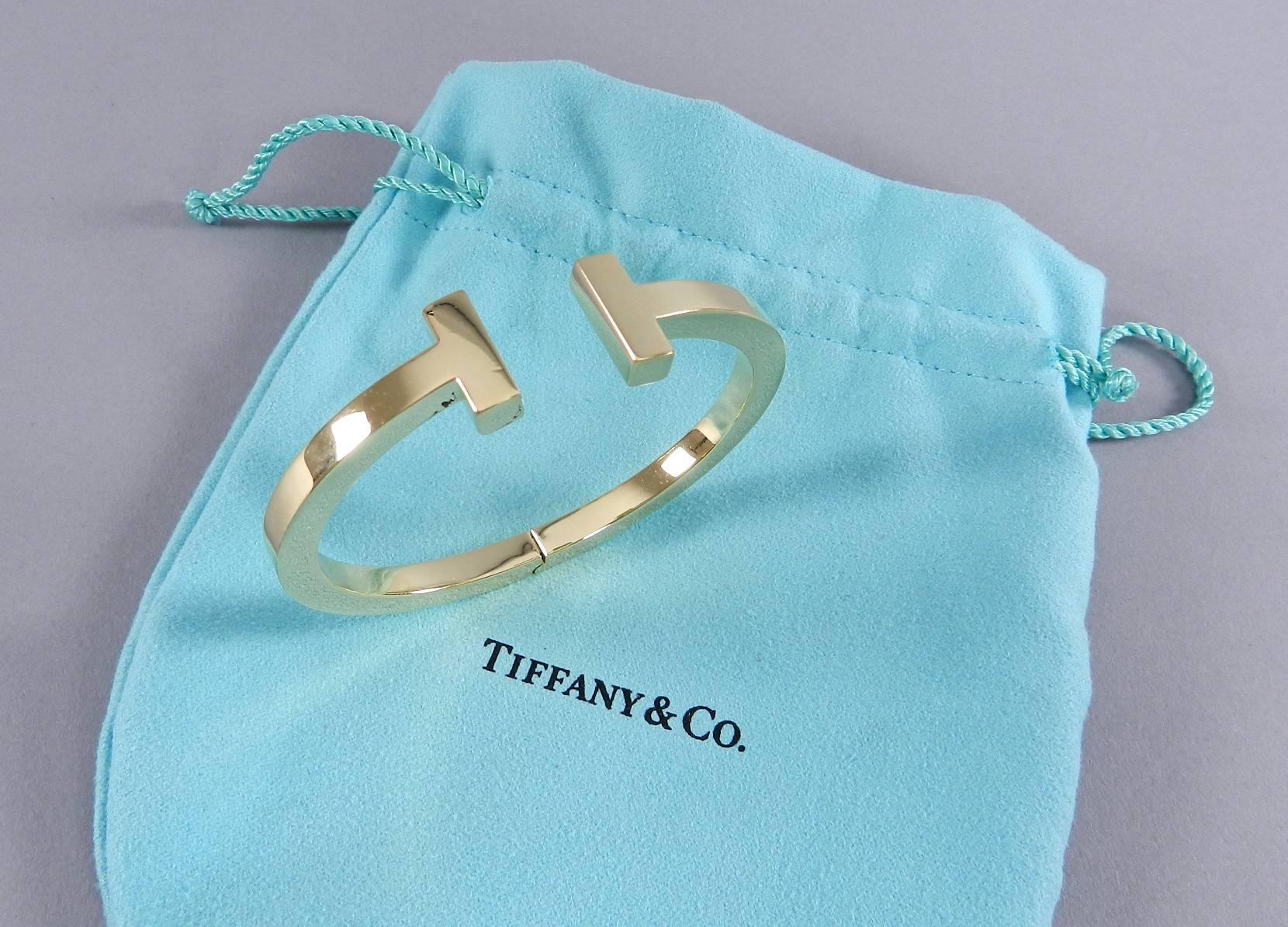 Tiffany and Co. medium T square 18k yellow gold hinged bracelet. Hallmarked (c) Tiffany and Co. AU 750 Italy. Measures 15 mm tall, 6.5