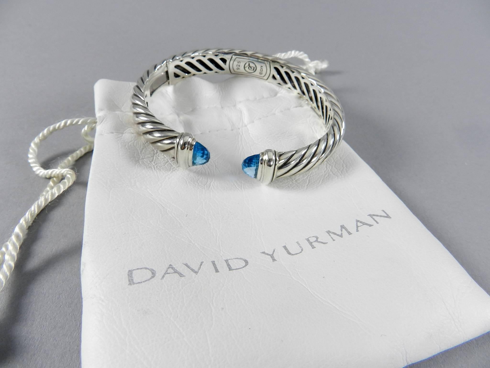 David Yurman Waverly sterling silver cuff bracelet with blue topaz. Hinged on one side. Measures 10 x 5 mm and interior circumference is 6.75”.  Excellent pre-owned condition. 

We ship worldwide.
