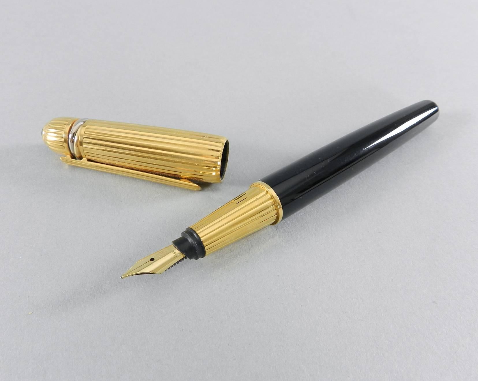 Pasha de Cartier fountain pen with inkwell.  Black and gold pen with onyx tipped cap.  Pen nib is marked 18k - 750. Pen lid is marked Pasha de Cartier 1989 with serial number 4770 and has a three metal trinity band design.  Inkwell has a frosted