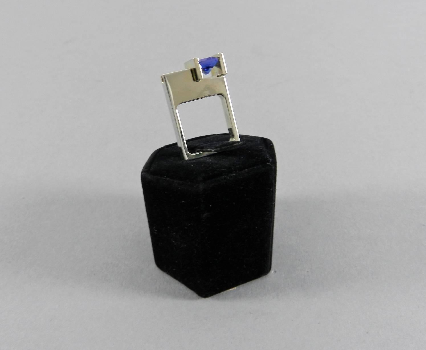 Custom Fancy design cocktail ring with tanzaite and diamonds set in 18k white gold. Angular Modernist abstract design with square shaped body. Signed Trisko 18k. 

1 radiant cut channel set tanzanite (approx. 2.08 ct, VS type 1) and 2 baguette cut