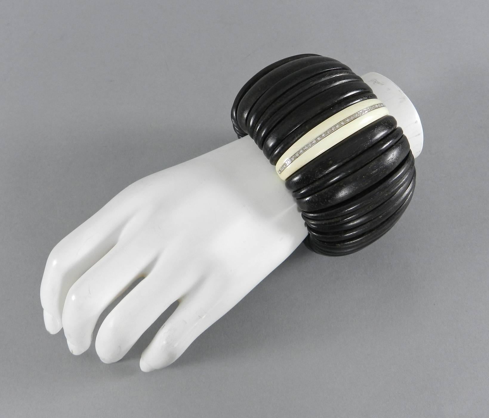 A chunky statement bracelet in ebony wood, ivory, and diamonds set in 18k white gold. Purchased at Demner Madison Avenue New York. Segmented stretch bracelet that can fit up to 7