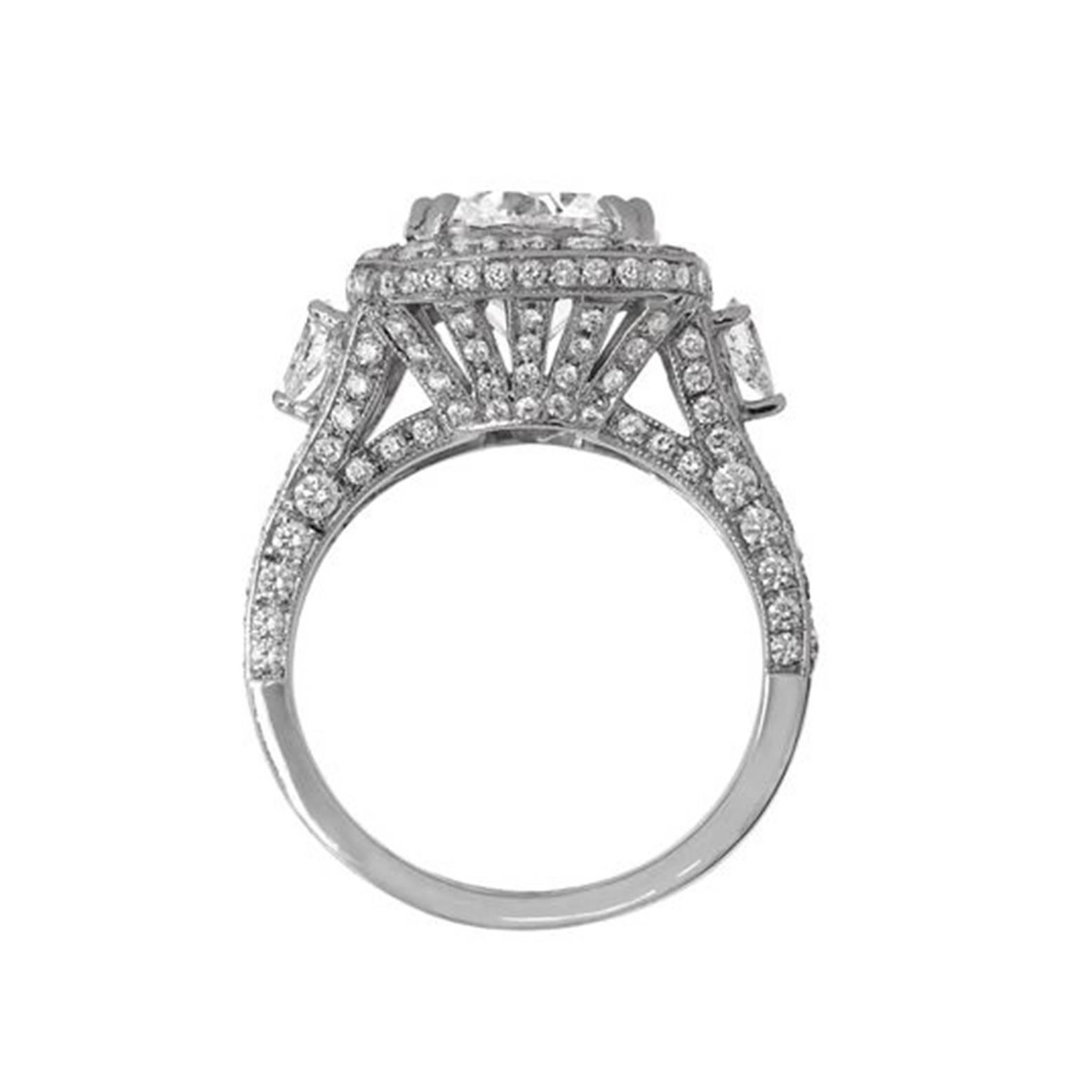Questo bellissimo anello di fidanzamento in oro bianco 18 carati presenta un diamante rotondo certificato EGL da 3,01 carati E-SI2 incastonato in una filigrana di diamanti con due forme a pera, con 2,00 carati di diamanti. Disponibile in 6 taglie.