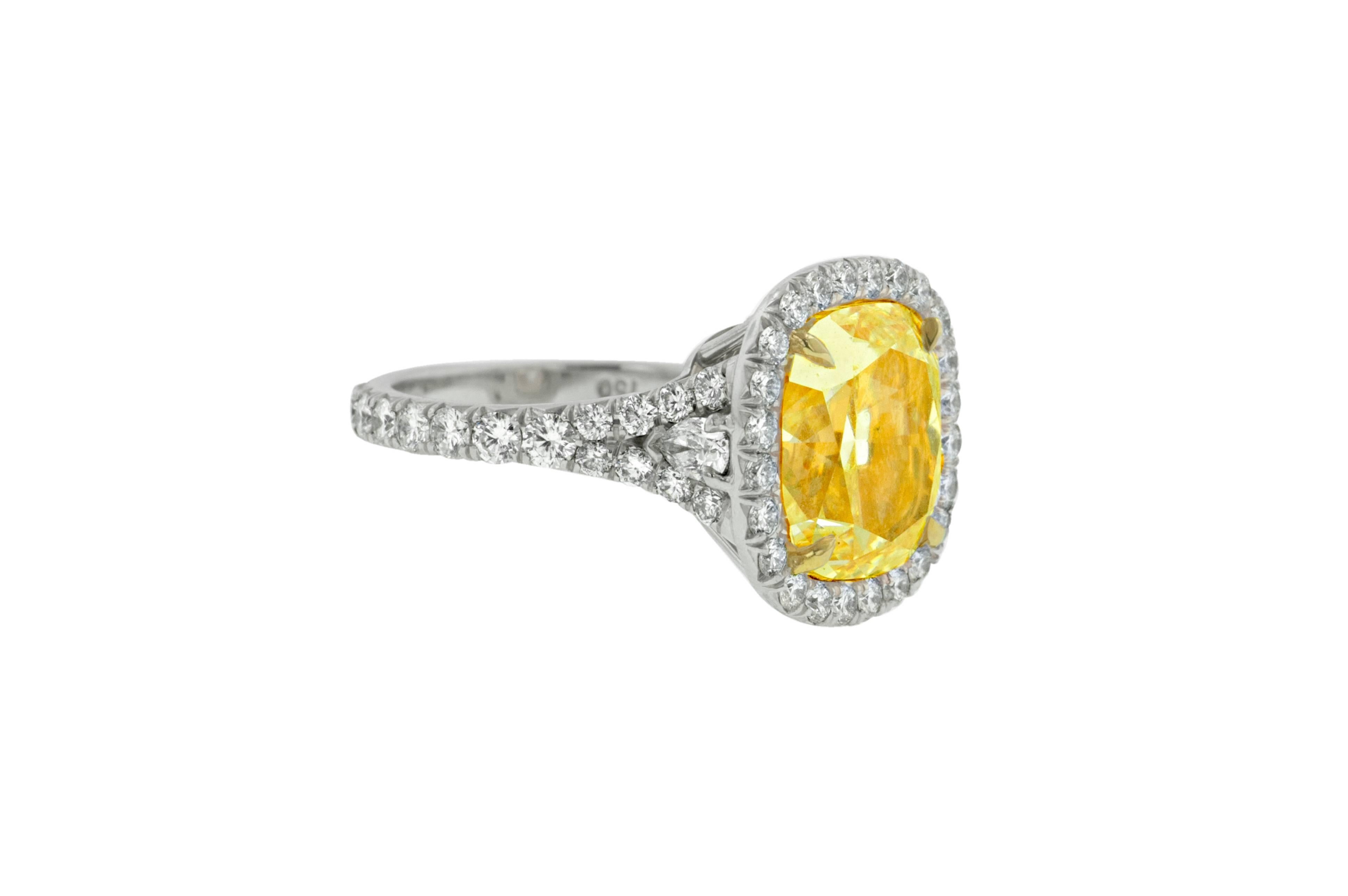 Platinum and 18 Karat Yellow Gold Fancy Yellow Diamond Ring, The center stone is 7.65 Carats Fancy Yellow in Color, VS2 in Clarity cushion cut diamonds, surrounded by 1.60 Carats of white diamonds around. 

