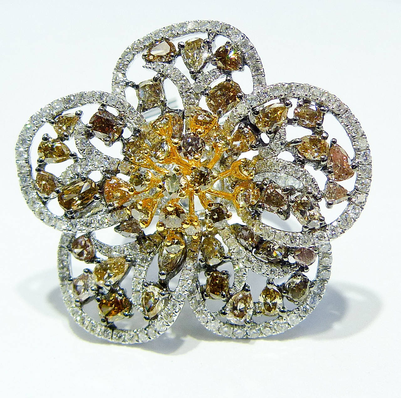This beautiful flower diamond ring, made of 18KT white gold and some touch of yellow gold, features 6.44 Carats of different color and different shape diamonds. 

All near colorless white, slightly included.