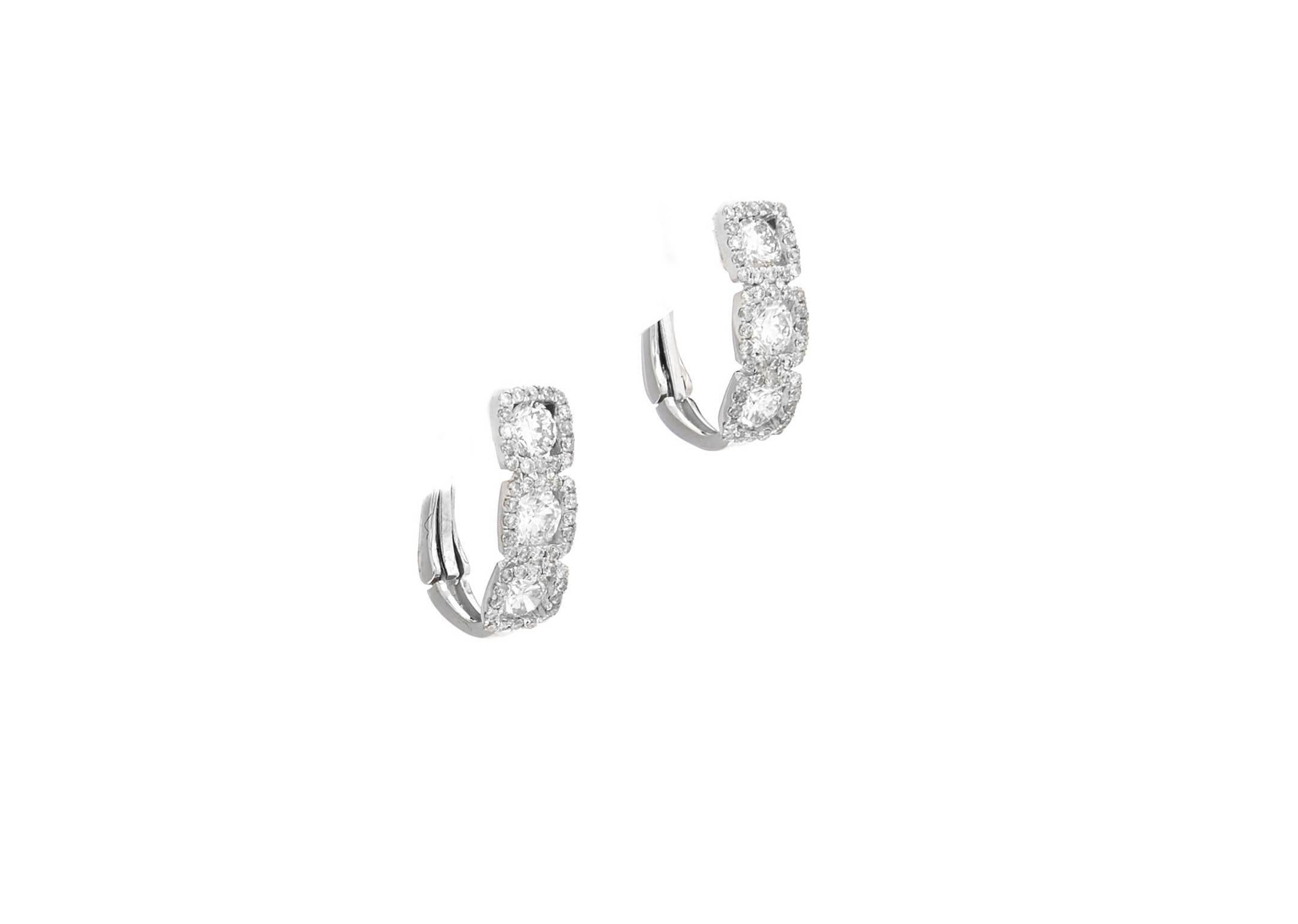 These classic diamond earrings features 1.50 Carat of round brilliant cut diamonds, Six larger size rounds, surrounded by smaller diamonds. 
