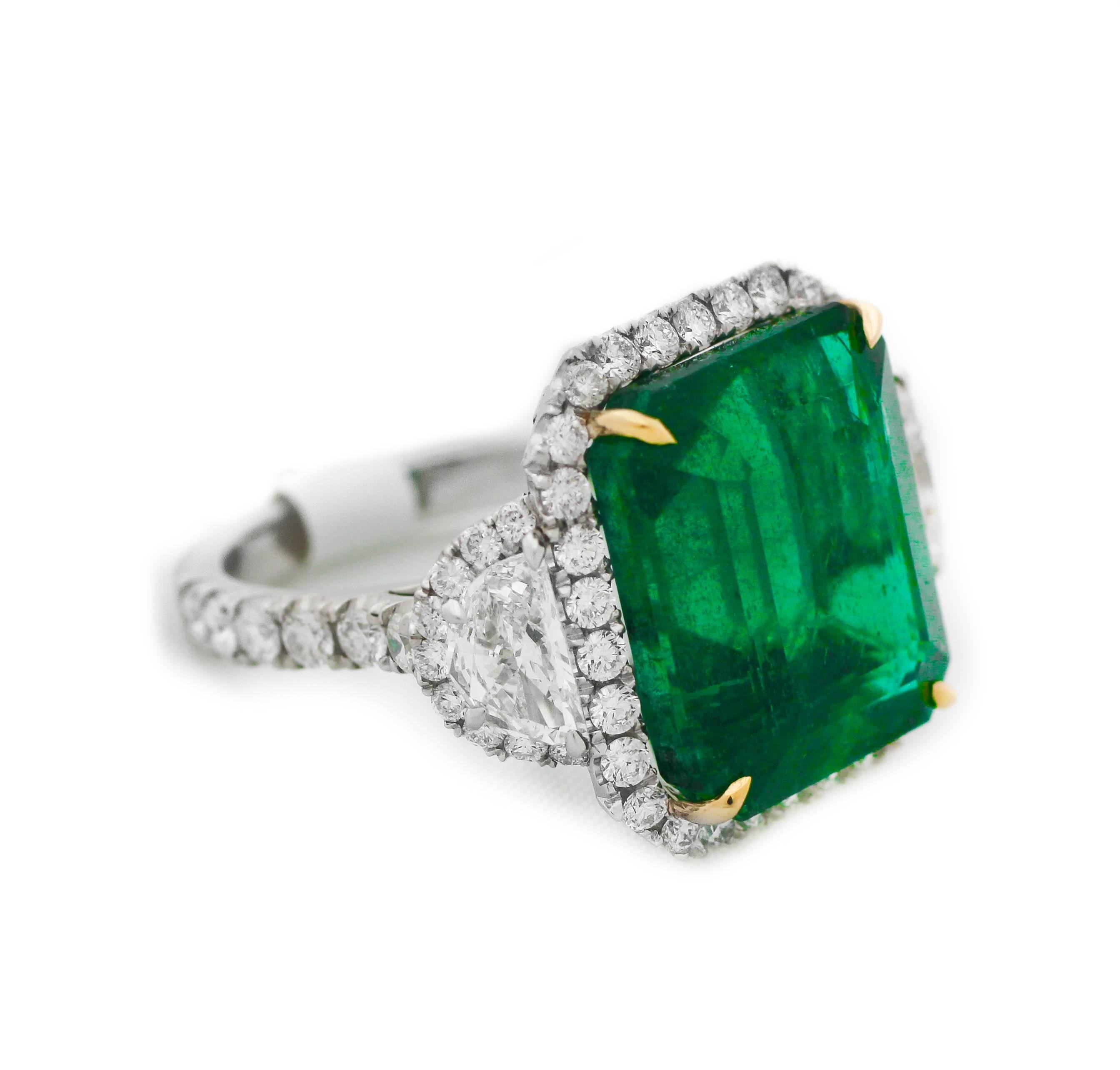 GIA-zertifizierter grüner Smaragd- und Diamantring, mit 14,13 Karat grünem Smaragd im Smaragdschliff, zertifiziert von GIA, besetzt mit zwei Halbmonden, umgeben von runden Diamanten im Brillantschliff, mit insgesamt 3,50 Karat Diamanten 
Hergestellt