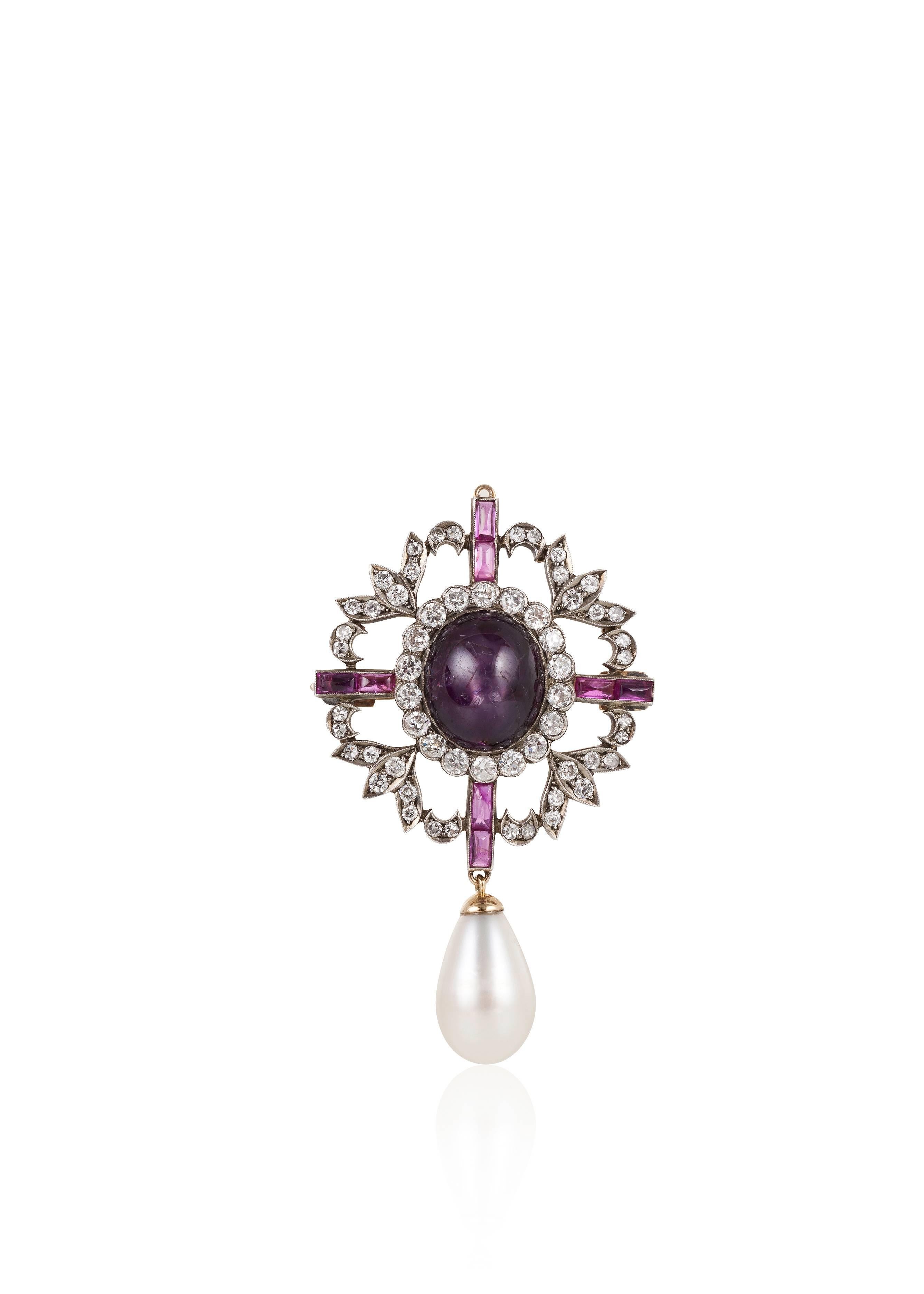 Composed of beautifully shaped natural pearl weighing 9.40 carats suspended from a cross and wreath pin centered around a star ruby, this pin also includes elongated cabochon rubies and round diamonds.