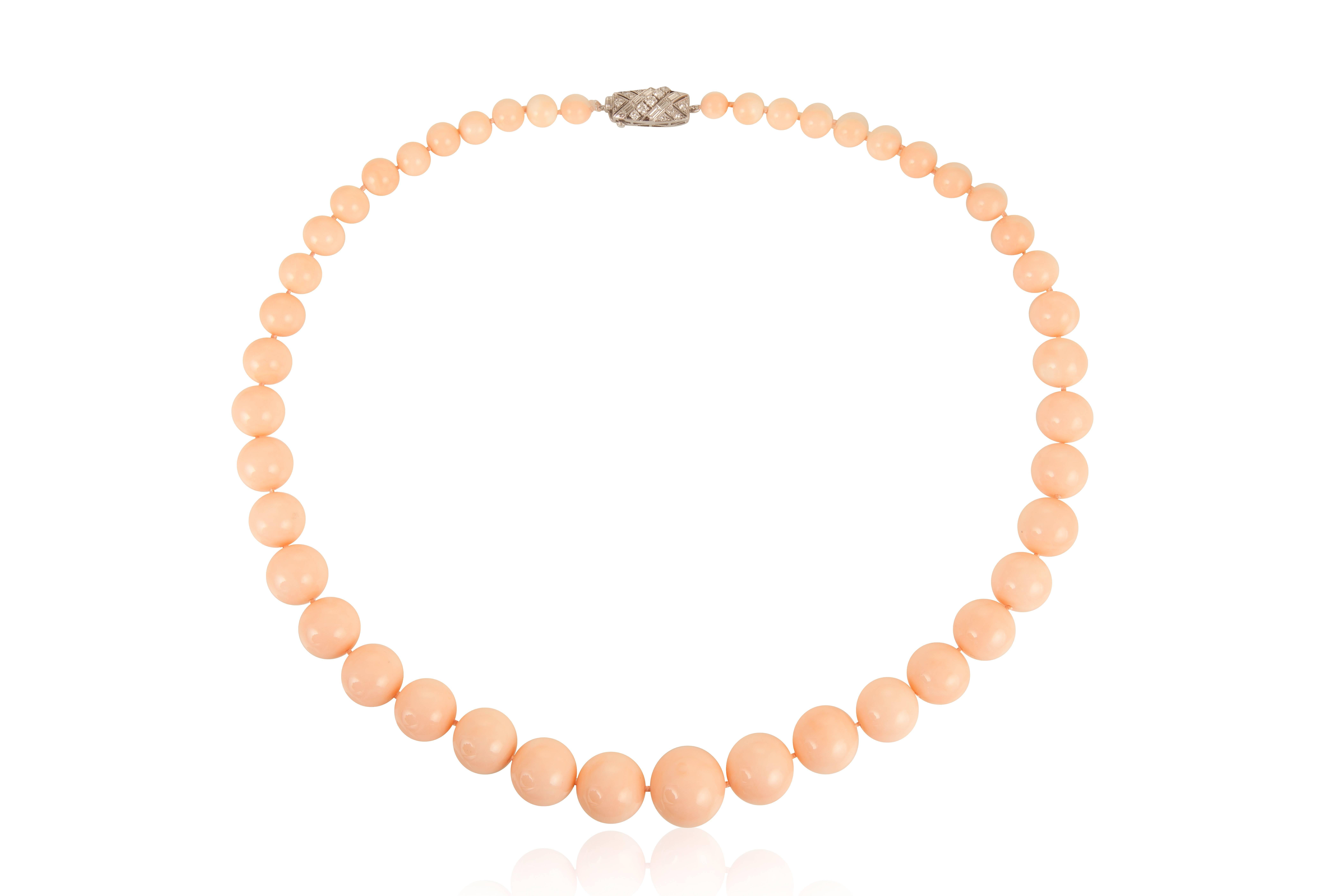 A necklace with 43 graduated beads of “angel skin” coral of great luster, homogenous material, and virtually flawless skin, finished with a tasteful round and baguette diamond clasp.
Dimensions: 22 ¼” long