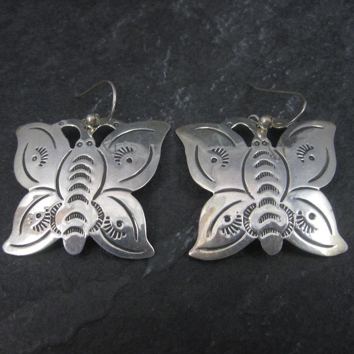 Questi bellissimi orecchini a farfalla del Sud-Ovest sono in argento sterling.

Misure: 1 5/16 per 1 9/16 pollici dalla parte superiore del filo dell'orecchio
Peso: 6,1 grammi

Marchi: Sterling

Condizioni: Eccellente

Questi orecchini sono stati