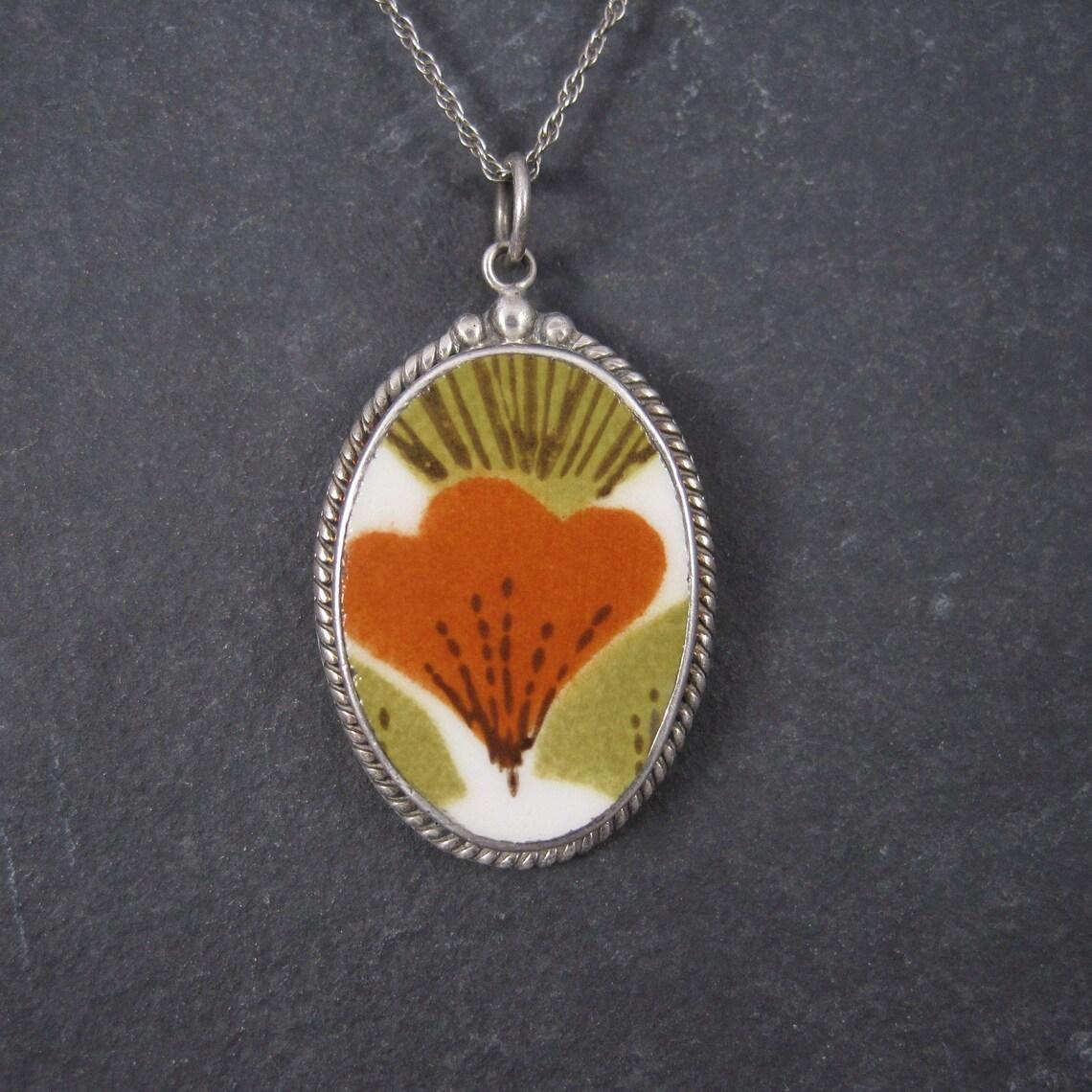 Questo bellissimo ciondolo è in argento sterling.
Presenta uno splendido pezzo di ceramica/porcellana riciclata degli anni '70.

Misure: 1 pollice per 1 pollice e mezzo
Viene fornito con una catena in argento sterling da 18 pollici.

Condit: