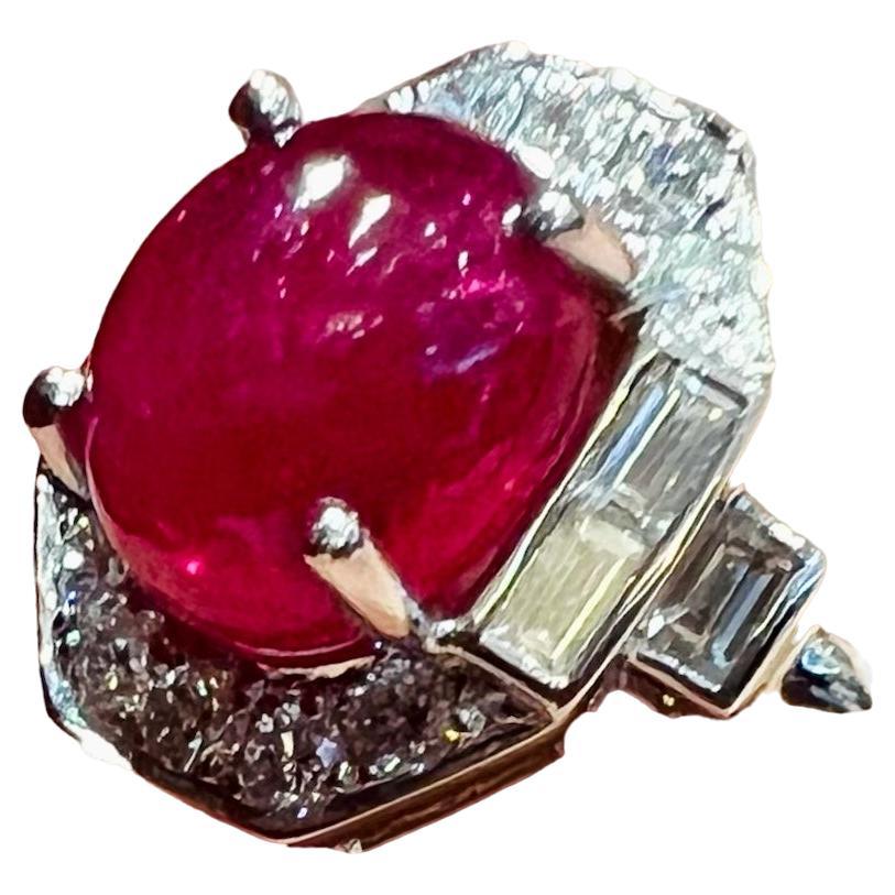 18-carat white gold ring set with a 3.30 carat ruby cabochon

Surrounded by brilliant-cut diamonds and baguette-cut

Ruby of a pretty sustained red pulling towards the raspberry,

Having no trace of wear

The montage of the 1980s takes up the lines