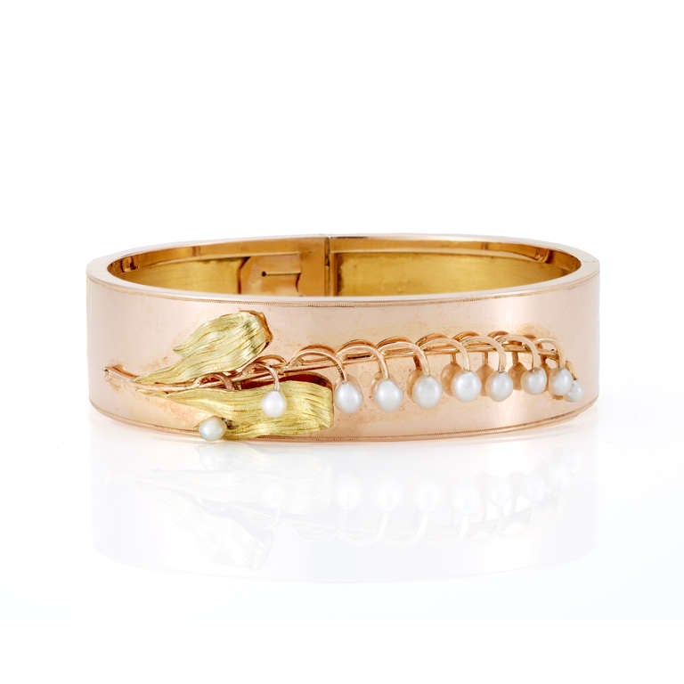 Napoleon III 18K rose gold bangle bracelet, decorated with a pearl lily-of-the-valley with yellow gold leaves, with a double hinge. French, circa 1860.

Sentimental jewelry was extremely popular during the Victorian period. There was an emphasis on