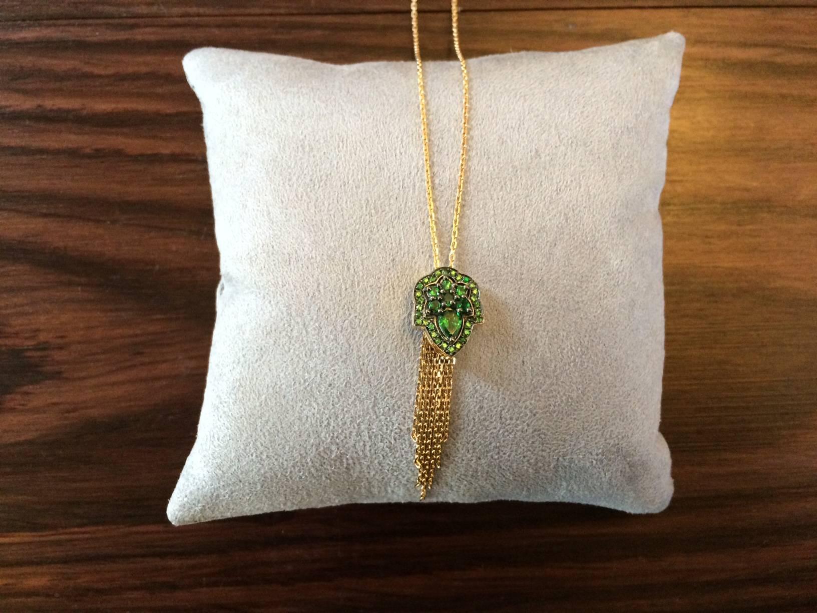 This pendant is handcrafted in London using 18ct yellow gold and is set with 1.20ct of vivid green natural tsavorites. The top of the pendant has a black rhodium finish to contrast with the yellow gold and the tsavorites. 

length of pendant
