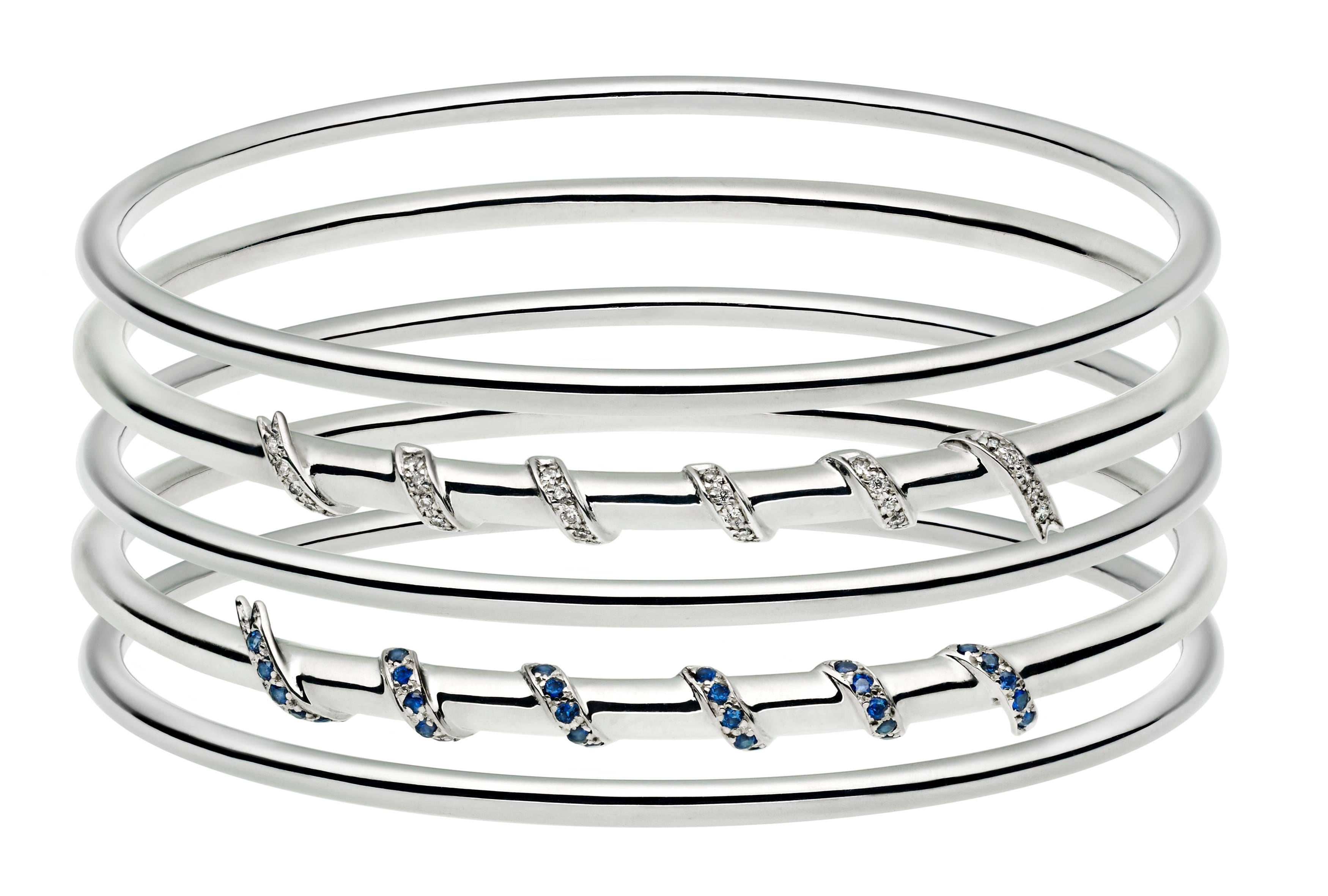 The bangle is crafted from solid 18ct white gold and pave set with 0.35ct F vs colour white diamonds which are set into the elegant ribbon which wraps around the top section. A range of colour ways of golds and gemstones can be ordered. 

The