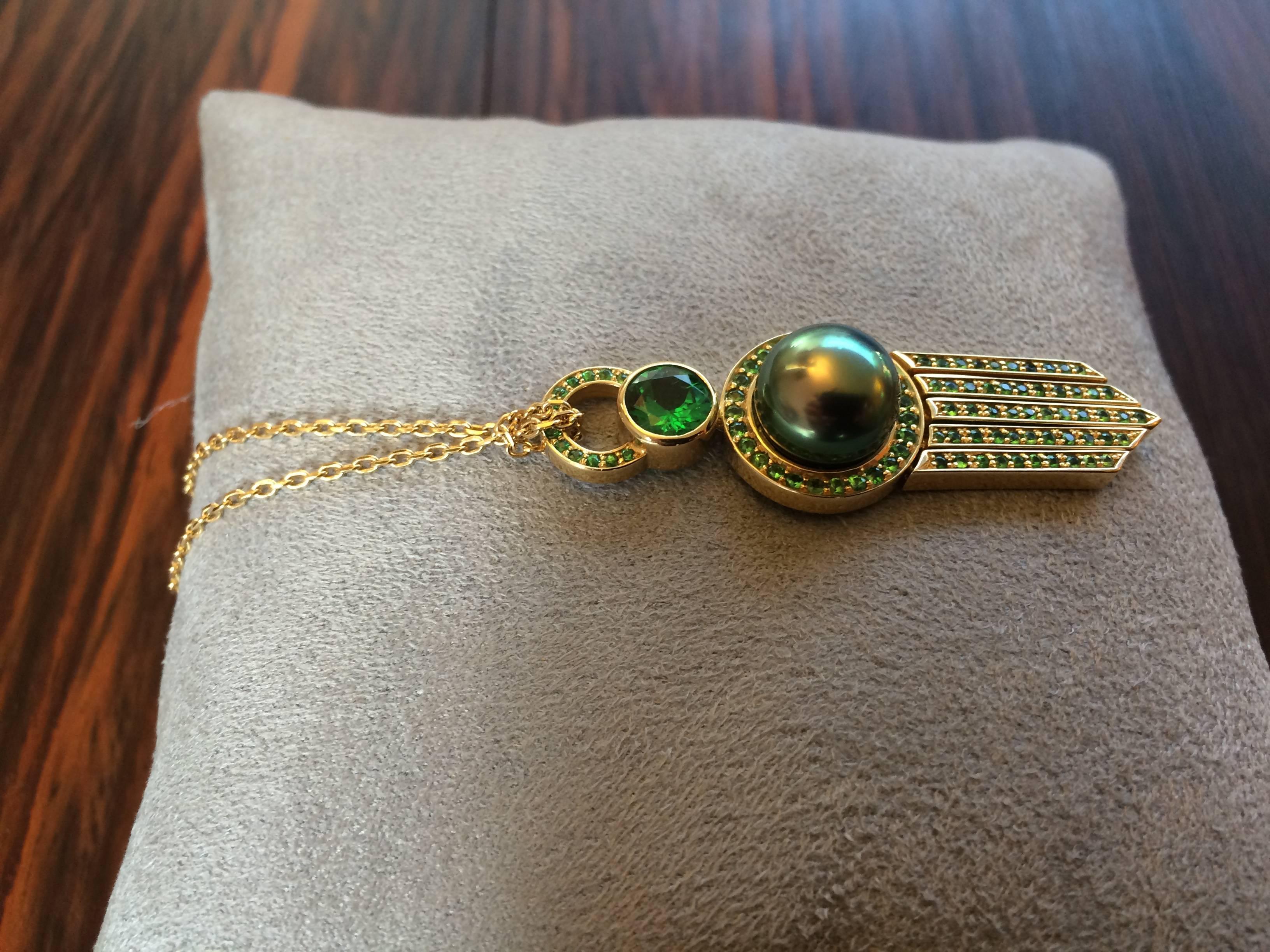 This pendant has been handcrafted in 18ct yellow gold and is a unique one of a kind piece. The large natural tsavorite weighs 0.93ct and the total tsavorite weight is 2.20ct. 

The black Tahitian pearl is 11mm in diameter and is an A grade pearl. It