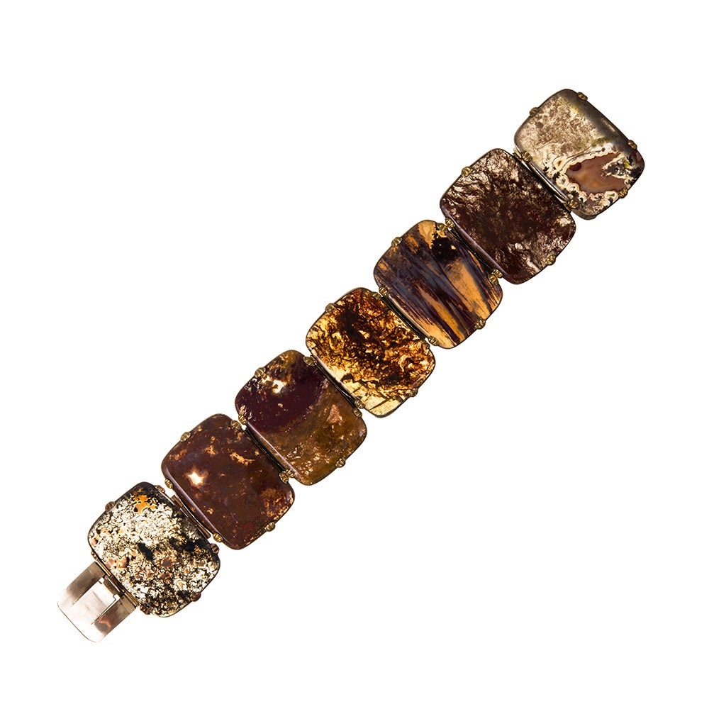 A striking collection of seven polished agates, set in golden bezels and contained with shell-shaped prongs. 6.75 inches in overall length and 1.25 inches tall. This piece has gorgeous natural allure and can be worn with everything. Enjoy!