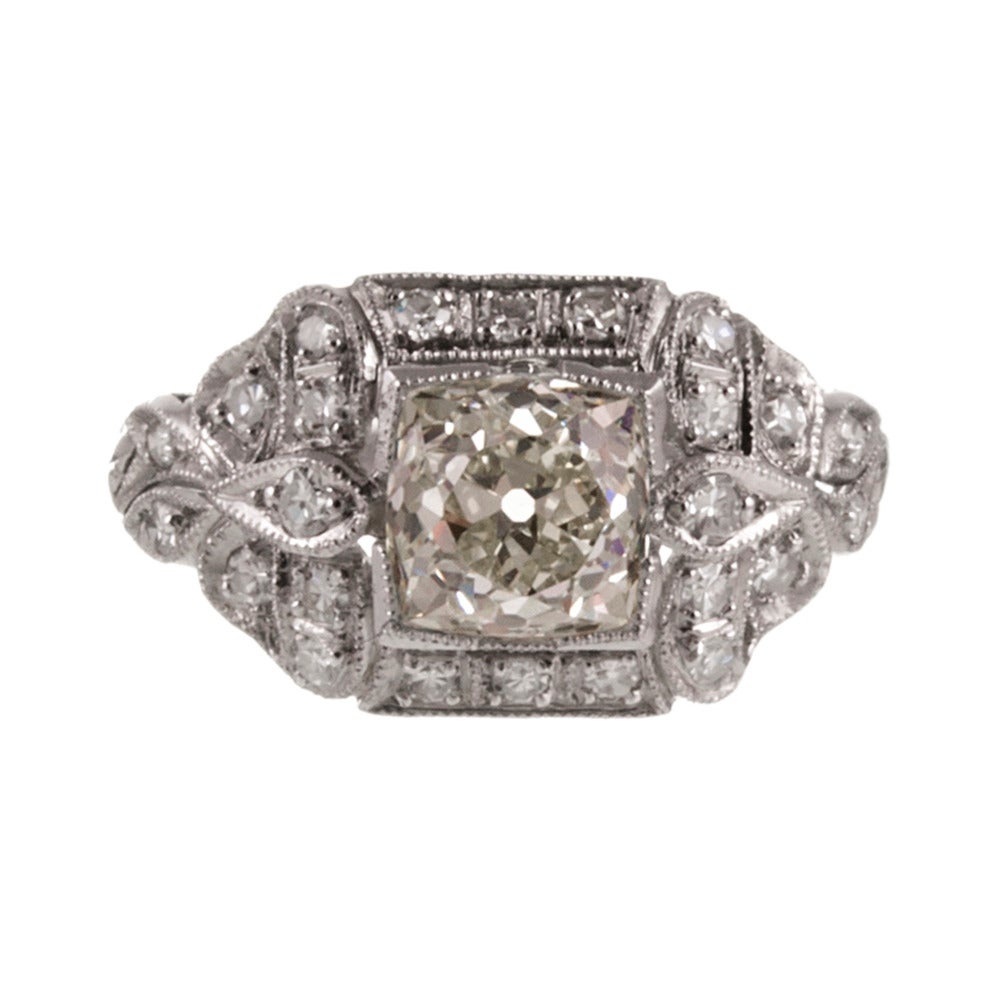 An original art deco piece, made circa 1930s. The center diamond is a 1.35 carat old mine cut that grades L color and Vs2 clarity. The mounting is a feminine and finely-detailed rendering of Edwardian-inspired accents, resulting in a gorgeous frame.