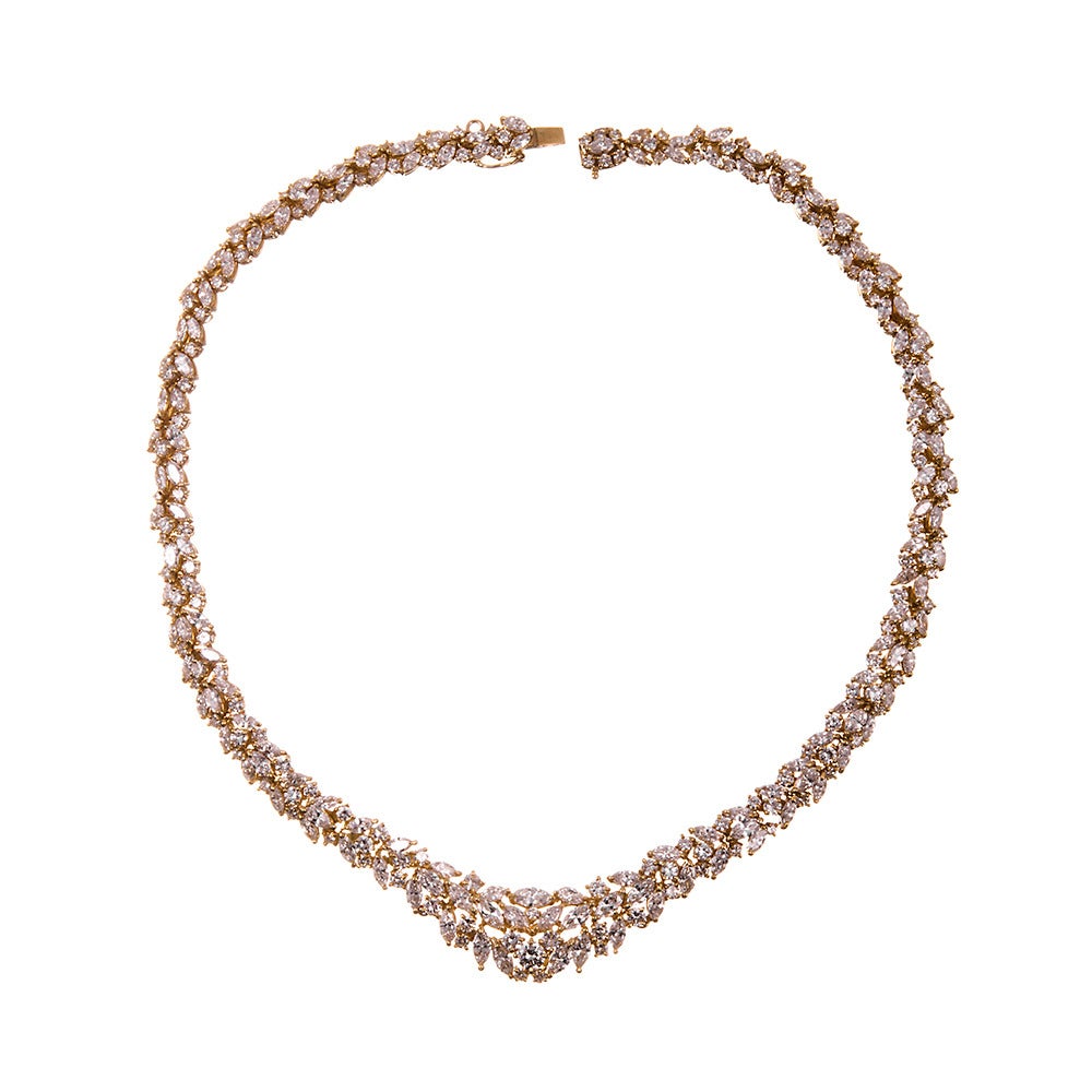 A stunning piece all around that is certain to collect some compliments, this necklace is made of 18k yellow gold and combines mixed cuts of diamonds, fashioned into a gentle “vee” shape with a substantial cluster at the front. Light dances off
