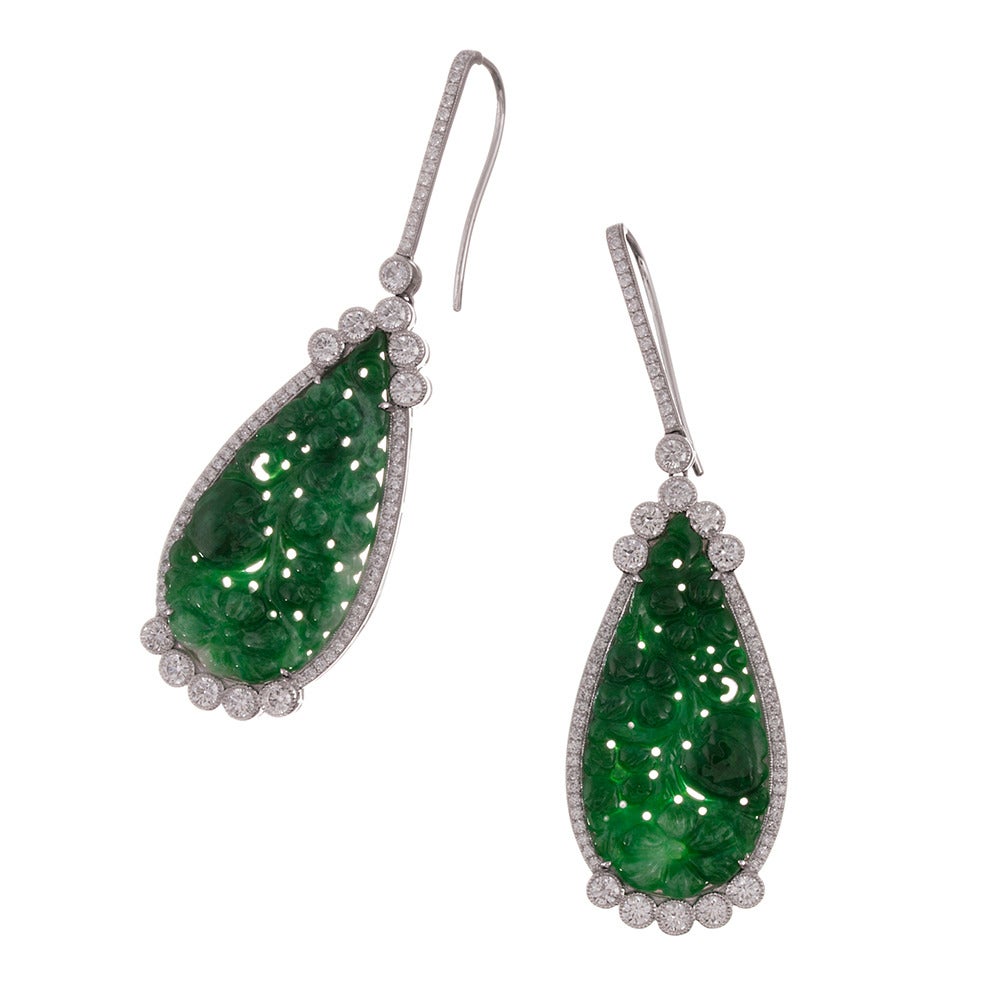 At just a hint under 2.5 inches in overall length, these striking earrings make an elegant statement, pairing dramatic size with organic beauty. The jade is carved with an intricate floral pattern, with the diamond frame custom-designed to ideally