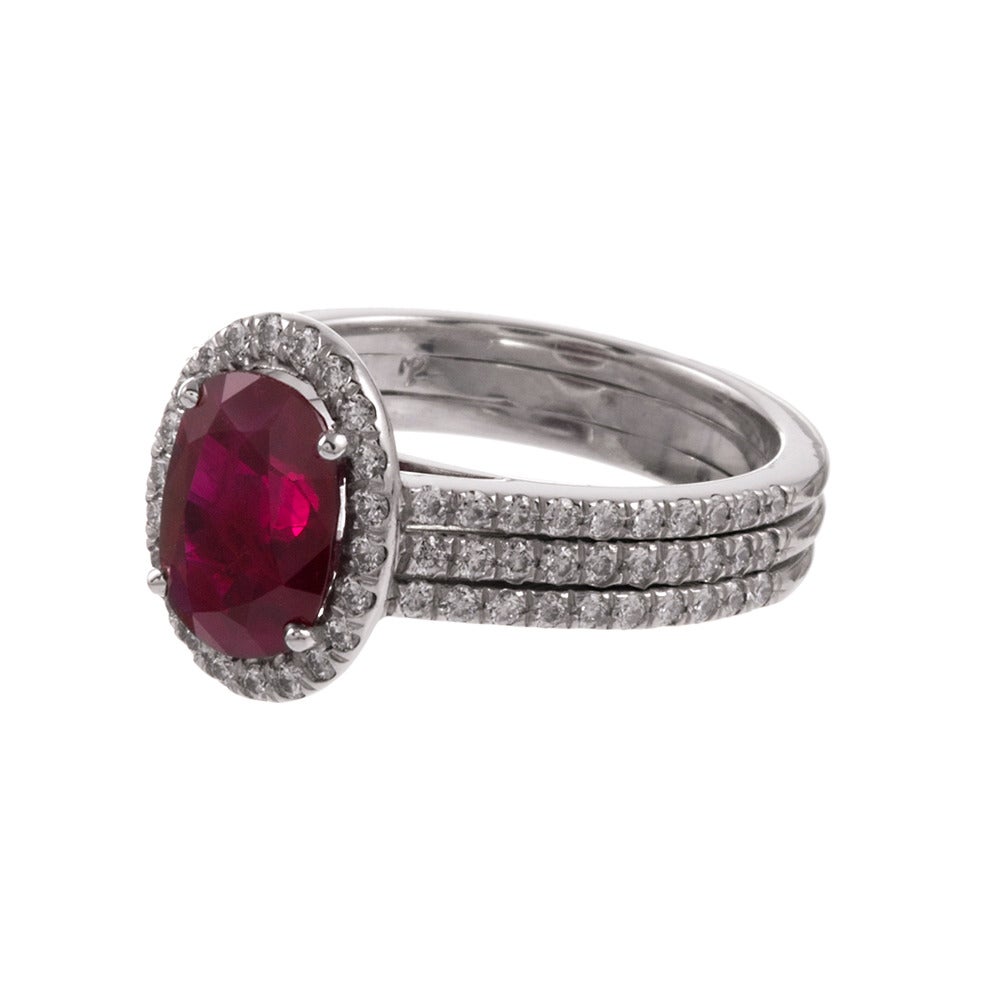 A pure and unencumbered design, celebrating the natural beautiful nestled at its center: a 2.60 carat oval ruby. The platinum mounting consists of a diamonds frame and a three-row diamond shank, adding brightness and creating a dramatic pop of color