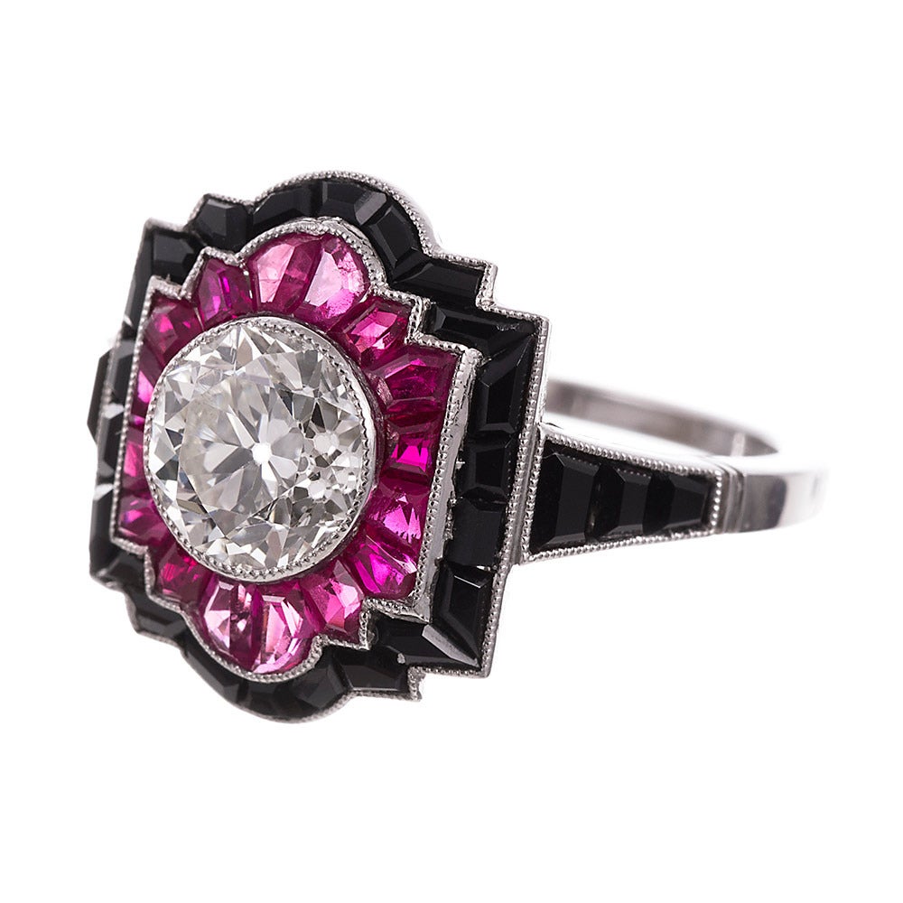 Hand made platinum ring, crafted in the traditional art deco style with an abundance of fine detail, and set in the center with a diamond solitaire, then framed by custom-cut tile set onyx and rubies. This plaque style ring has a comfortable and