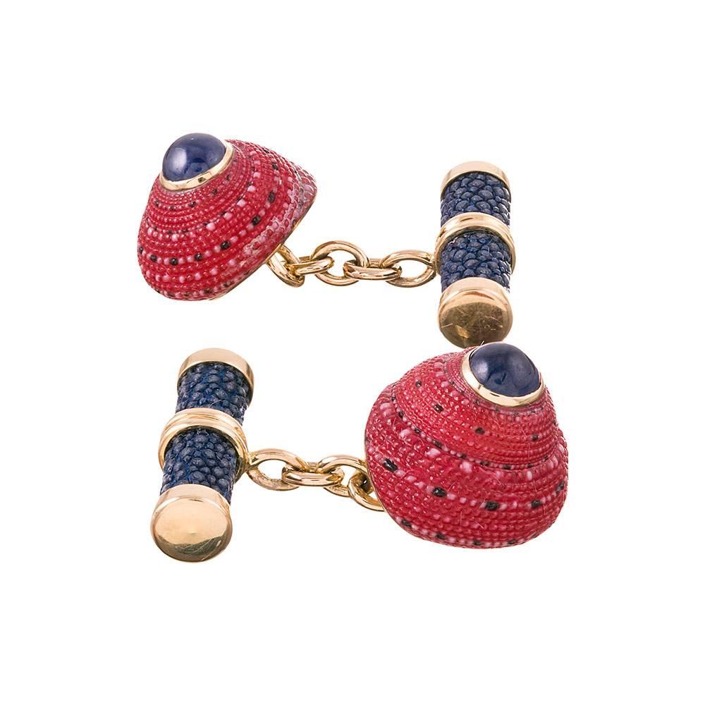 A charming pair of cufflinks, compliments of the esteemed house of Trianon, a division of famed American jeweler Seaman Schepps. These 18k yellow gold cufflinks are made of red Top shells and tipped with blue sapphire cabochons. The bars are set