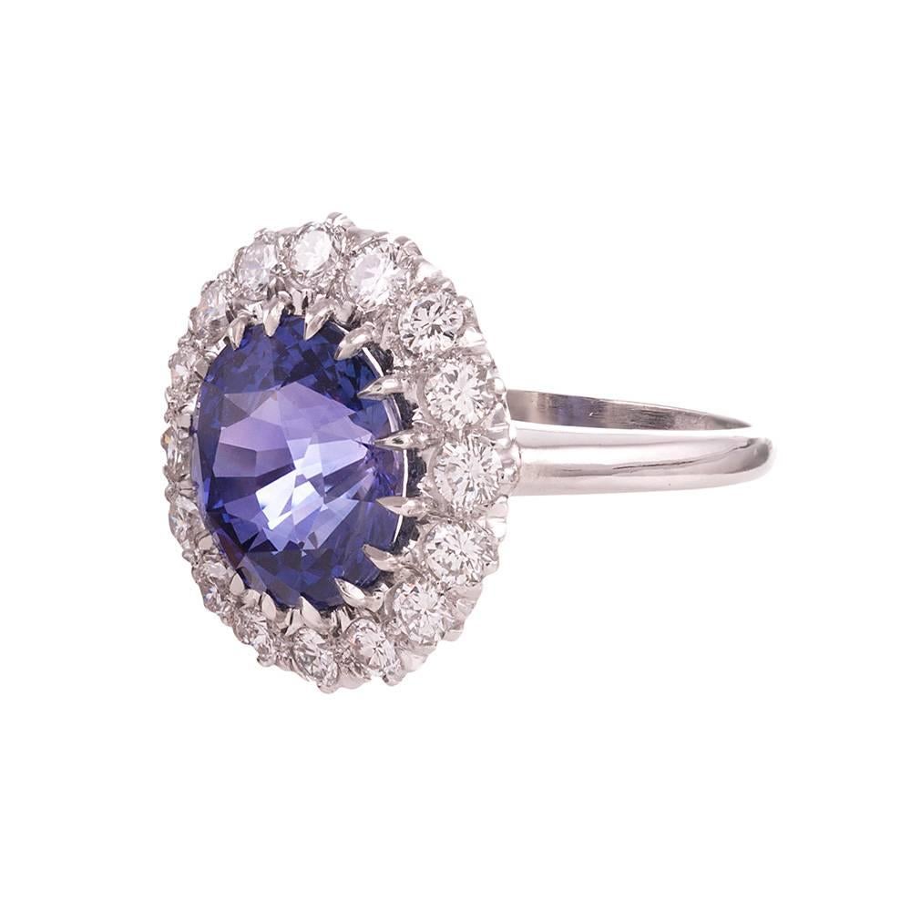 A classic design, offering a 5.23 carat round sapphire bursting from a border of brilliant white round diamonds. The diamonds weigh .90 carats in total. The sapphire has an alluring and unusual purplish blue color, furthering the distinction. Size