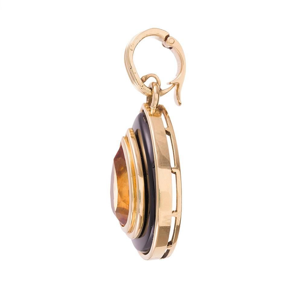 A pear-shaped citrine is framed by multiple layers of 18k yellow gold and black onyx. This piece has lovely fluid motion, as your eyes trace the contours of the layered design. 2.75 inches long with the bale and 1 inch wide. Add a golden chain,