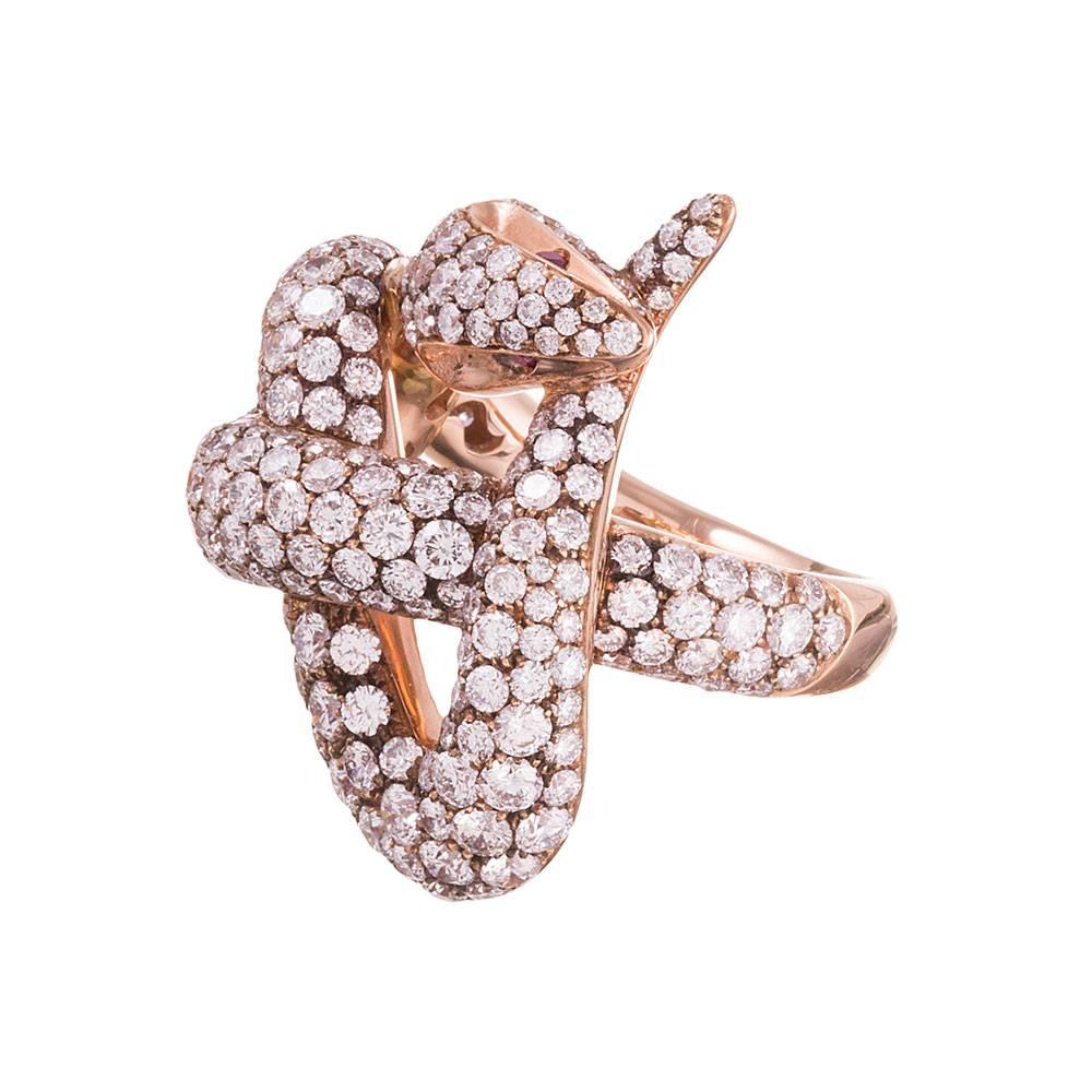 The serpent’s body has writhed into a knot, his tail clutched in his mouth. Look closely to appreciate the stylized features of his head. Assorted sizes of brilliant round white diamonds decorate his body, glistening from every angle. In total,