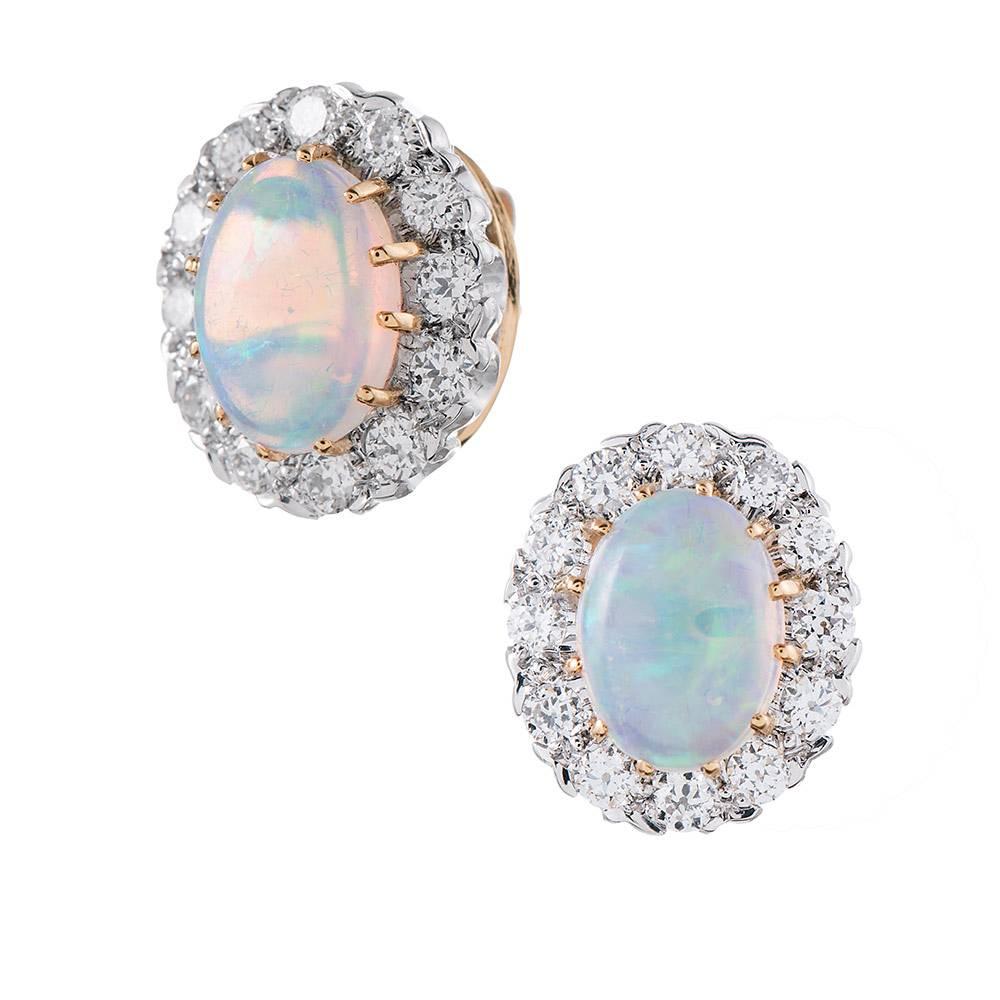 A modern rendering of a classic style, with cabochon oval opals framed in brilliant round white diamonds. The opals weigh 1.97 carats in total, while complimented by .93 carats of diamonds. Made of 18 karat white and yellow gold, these are of new