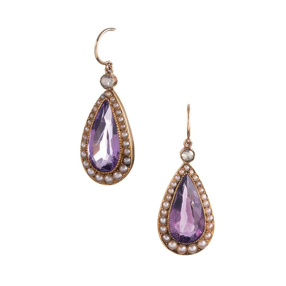 A faceted pear shaped amethyst sits surrounded by a frame of graduated natural pearls and topped with a rose cut diamond. At 1.25 inches long, these can be worn and enjoyed every day. 14k yellow gold. 