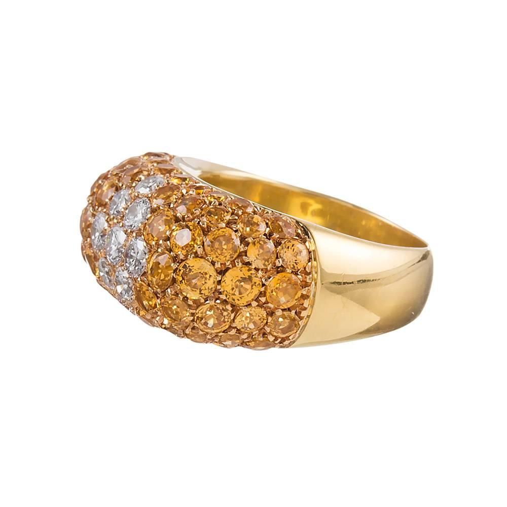 A gentle dome shape with squared edges enhances this half eternity band, decorated with 1.57 carats of diamonds and 4.50 carats of yellow sapphires. This sophisticated and fun piece offers a generous burst of color and is made of 18 karat yellow
