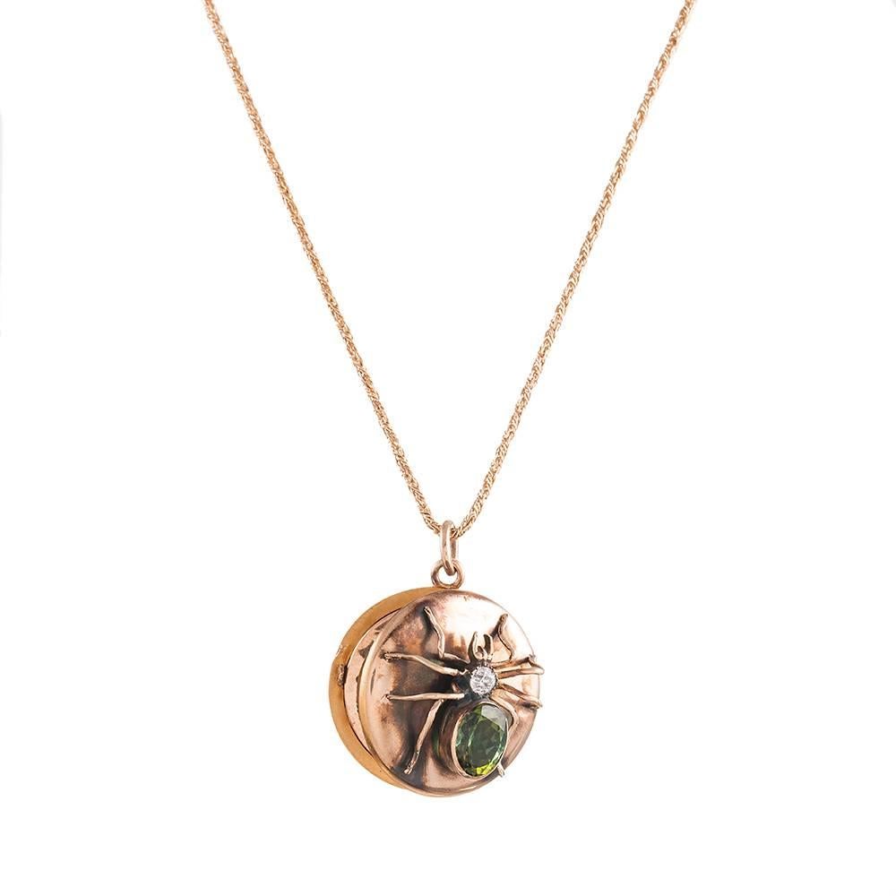 A charming little locket made of 12k rose gold and decorated with a three-dimensional spider. It’s body is set with a solitary diamond and green tourmaline. The locket opens to repeal a compartment in both sides to stash your relics. 7/8 of an inch