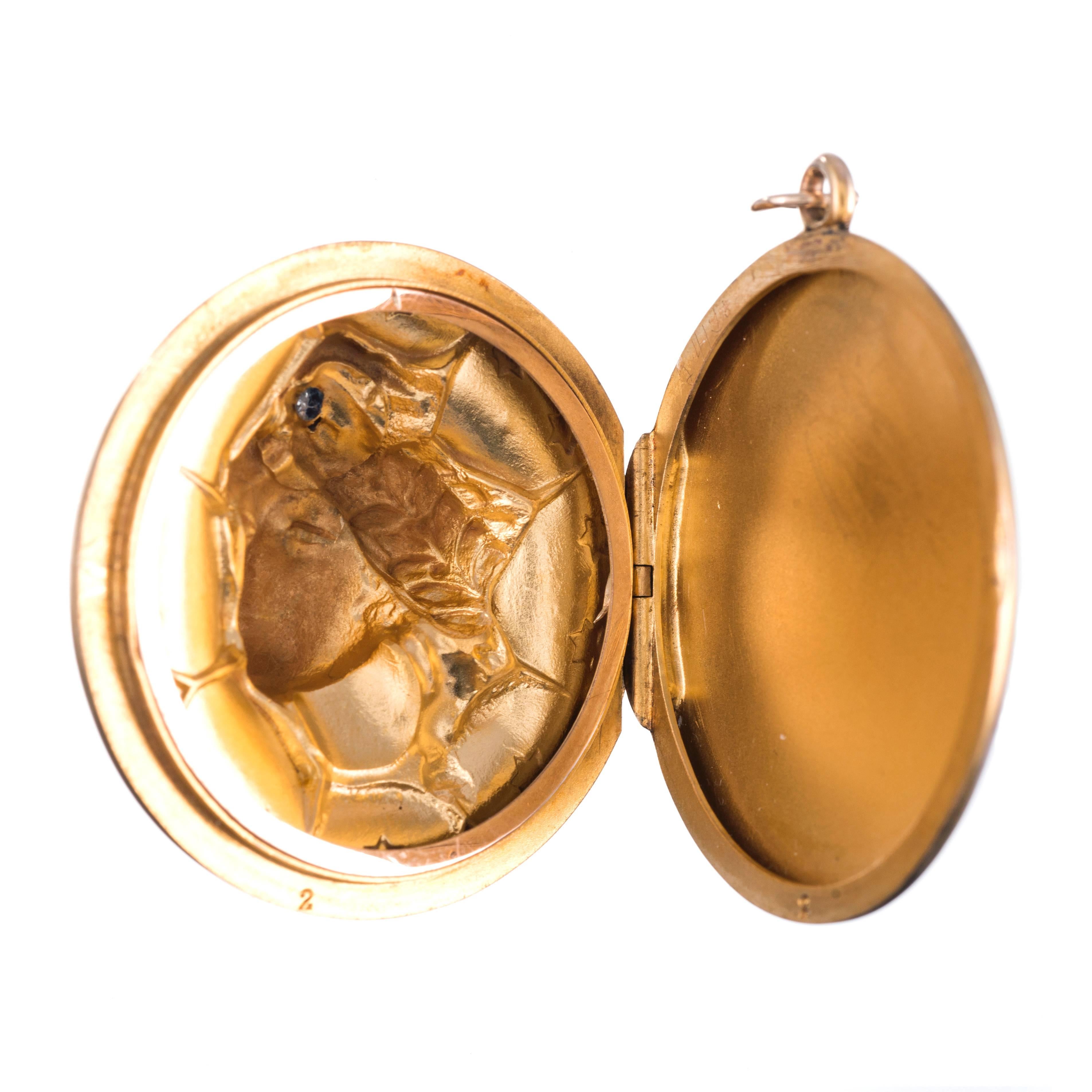 14k yellow gold original art nouveau locket, made in the US, circa 1915. The piece depicts a feminine profile, wearing a garland of leaves around her head, her forehead dotted with a diamond and framed by stars. The locket is in excellent repair,