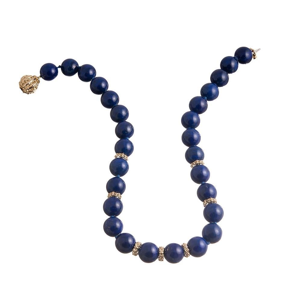 A striking arrangement of lapis lazuli beads and woven gold rondelles, part of the “Lightship” collection, compliments of American jewelry icon Seaman Schepps. The necklace measures 18 inches long. Mounted in 18k yellow gold.