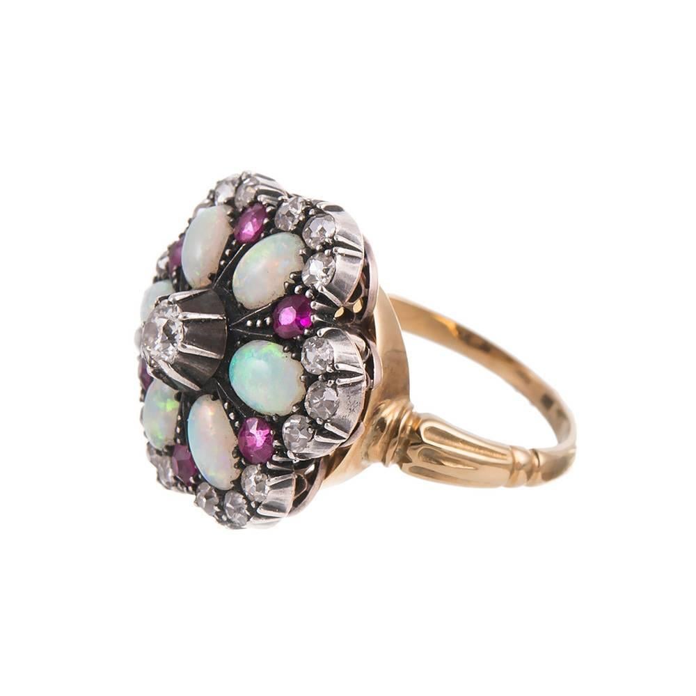 A modular design, allowing this stunning piece to be worn as a ring or pendant. This classic design, rendered in silver over yellow gold, combines old European cut diamonds with cabochon opals and faceted rubies- quite a striking combination of